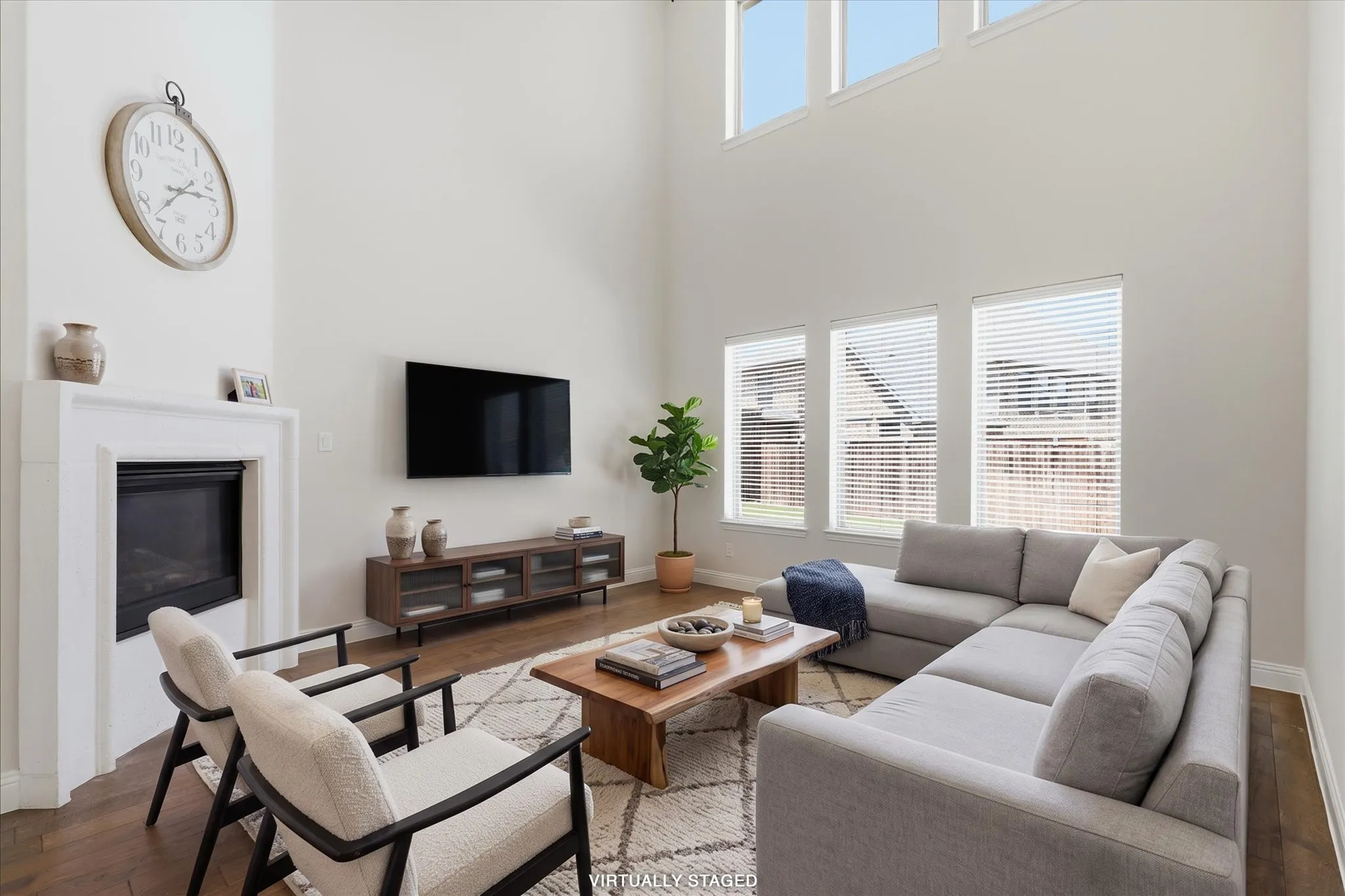Tall ceilings in the livingroom, fireplace, rich wood flooring, and lots of windows letting in tons of natural light.  Virtually staged.