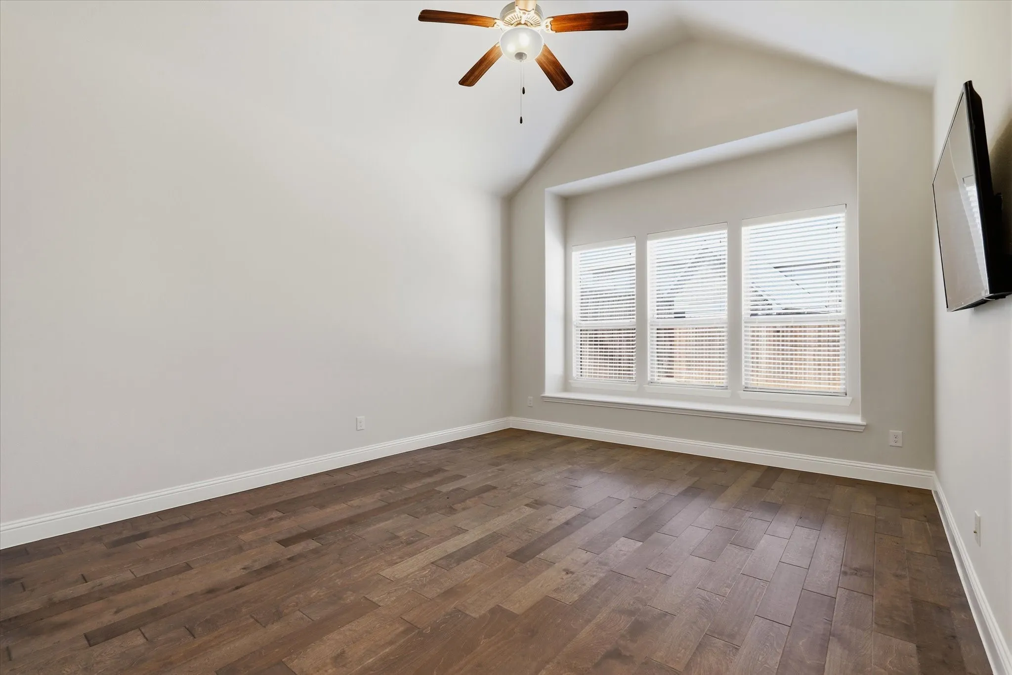Spacious Primary Bedroom with vaulted ceilings, wood flooring and nice natural light