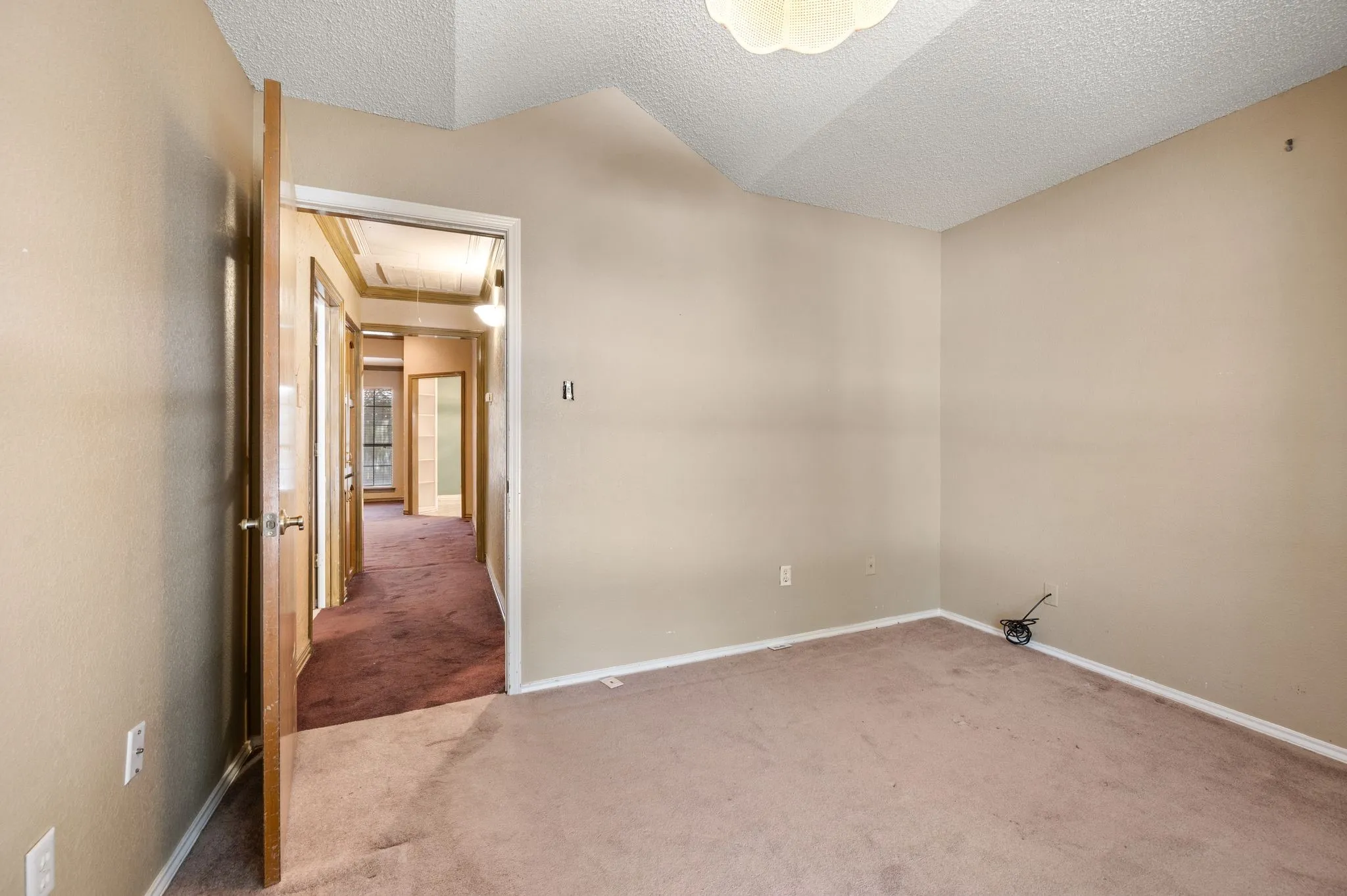 Carpeted flooring, vaulted ceiling, and interior wood-finish doors