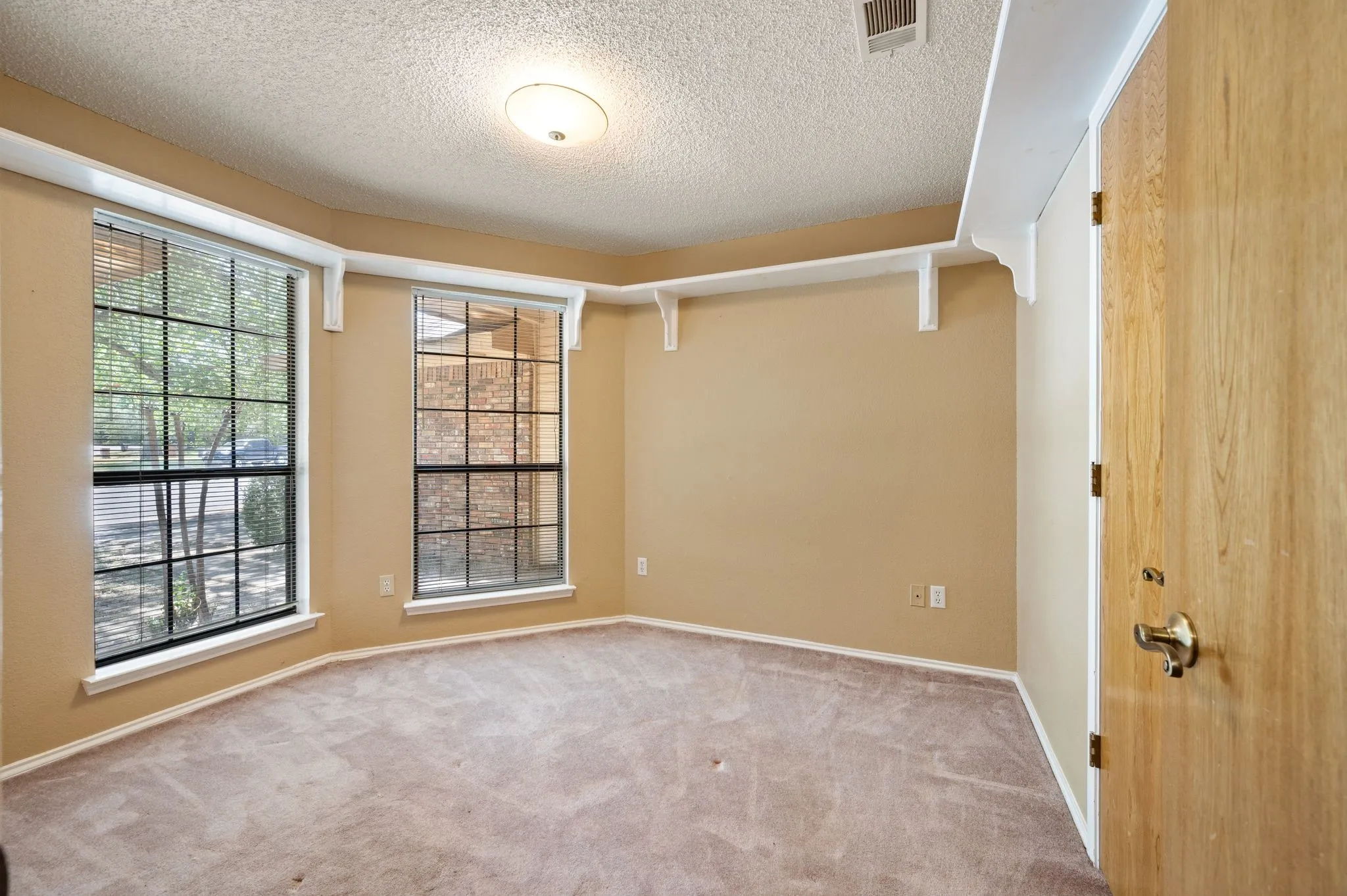 Room featuring bay windows, warm-toned walls, and a recessed light fixture
