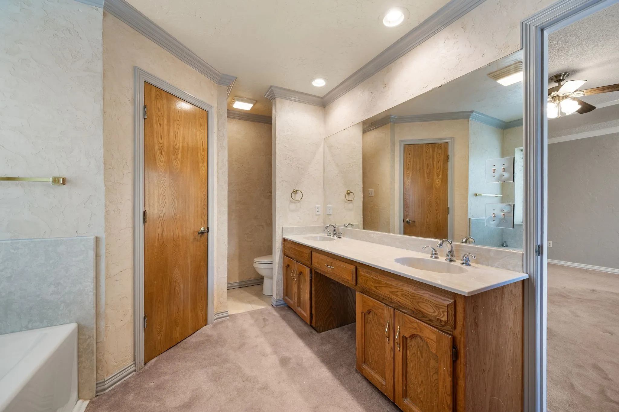 Dual vanity with integrated sinks, wood-finish cabinetry, and a full-width mirror