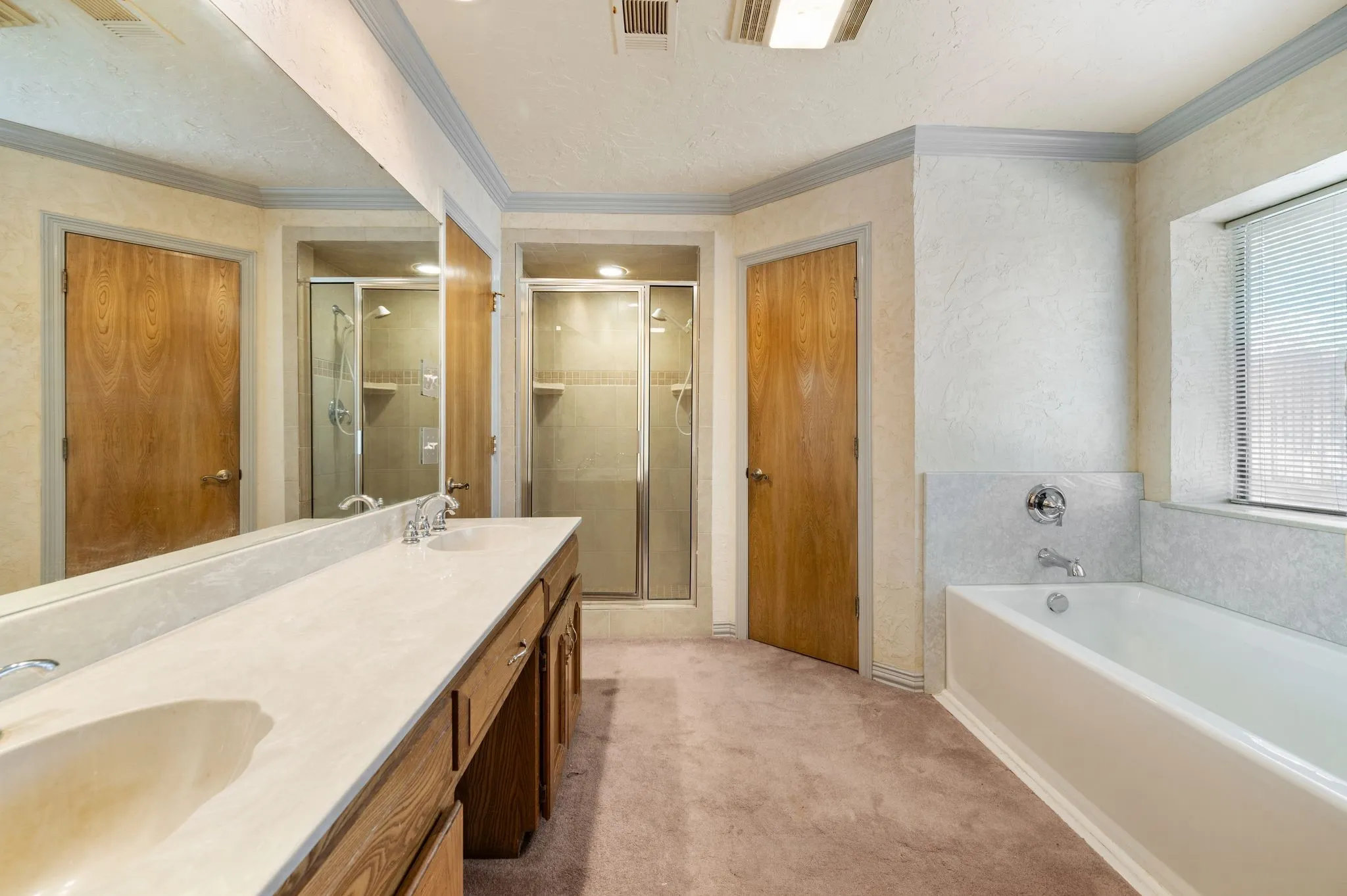 Dual sink vanity with integrated sinks, full-width mirror, and wood-finish cabinetry