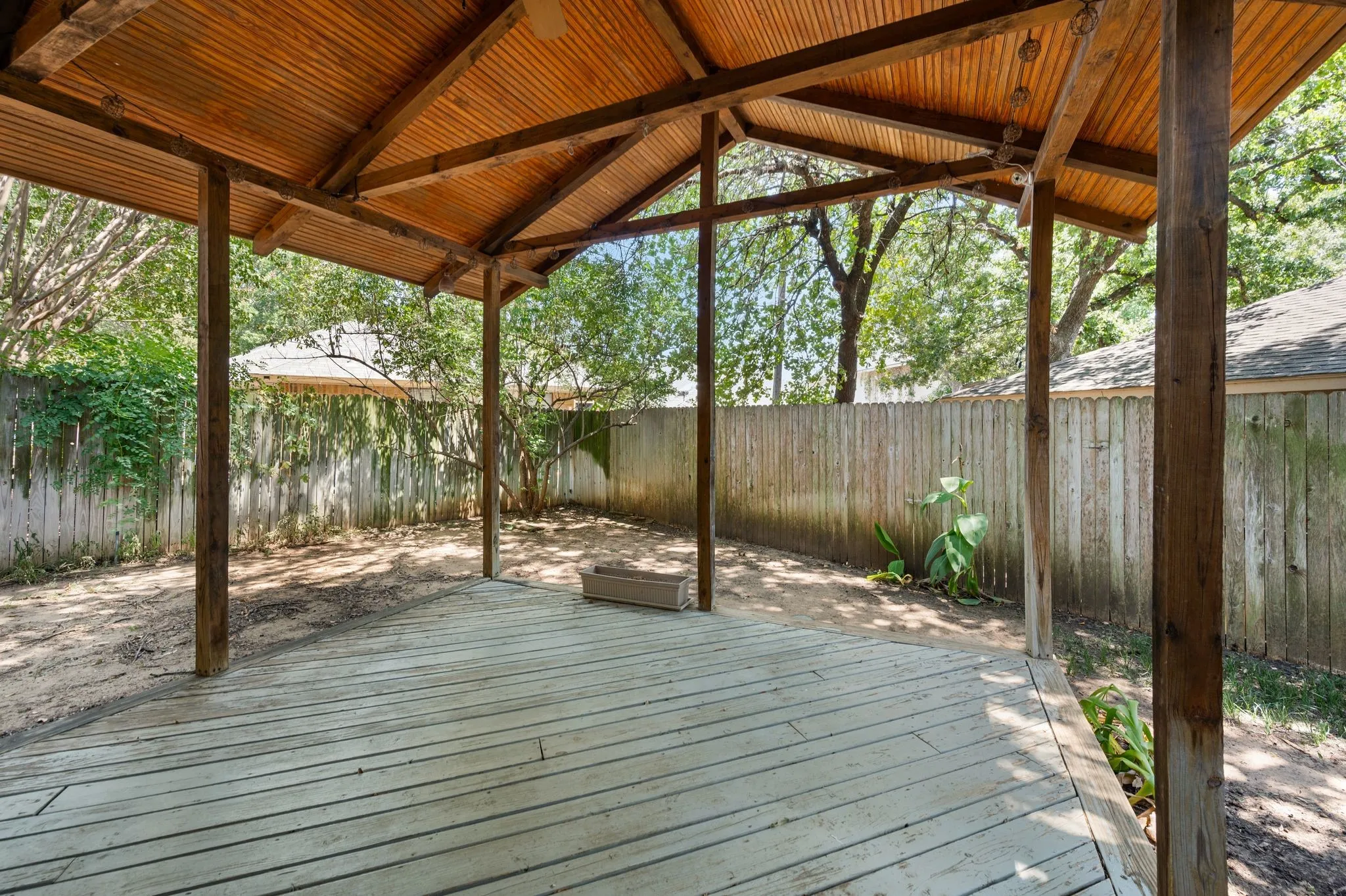 Expansive covered patio featuring a wood-finish deck, sturdy timber beam construction.