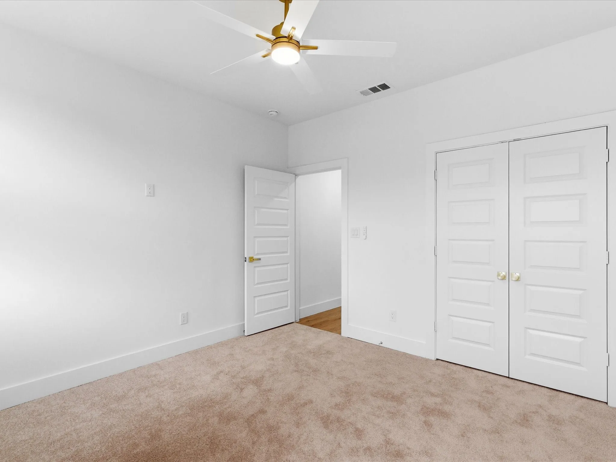 Recessed lighting, ceiling fan with light fixture, white interior doors with gold-finish hardware, and carpet flooring
