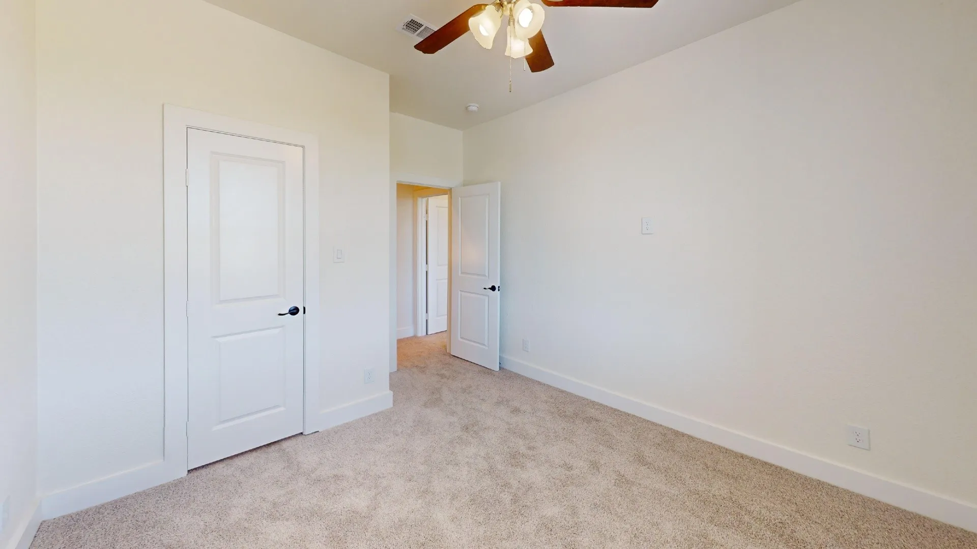 Neutral wall color, carpet flooring, ceiling fan with light fixture, and white interior doors