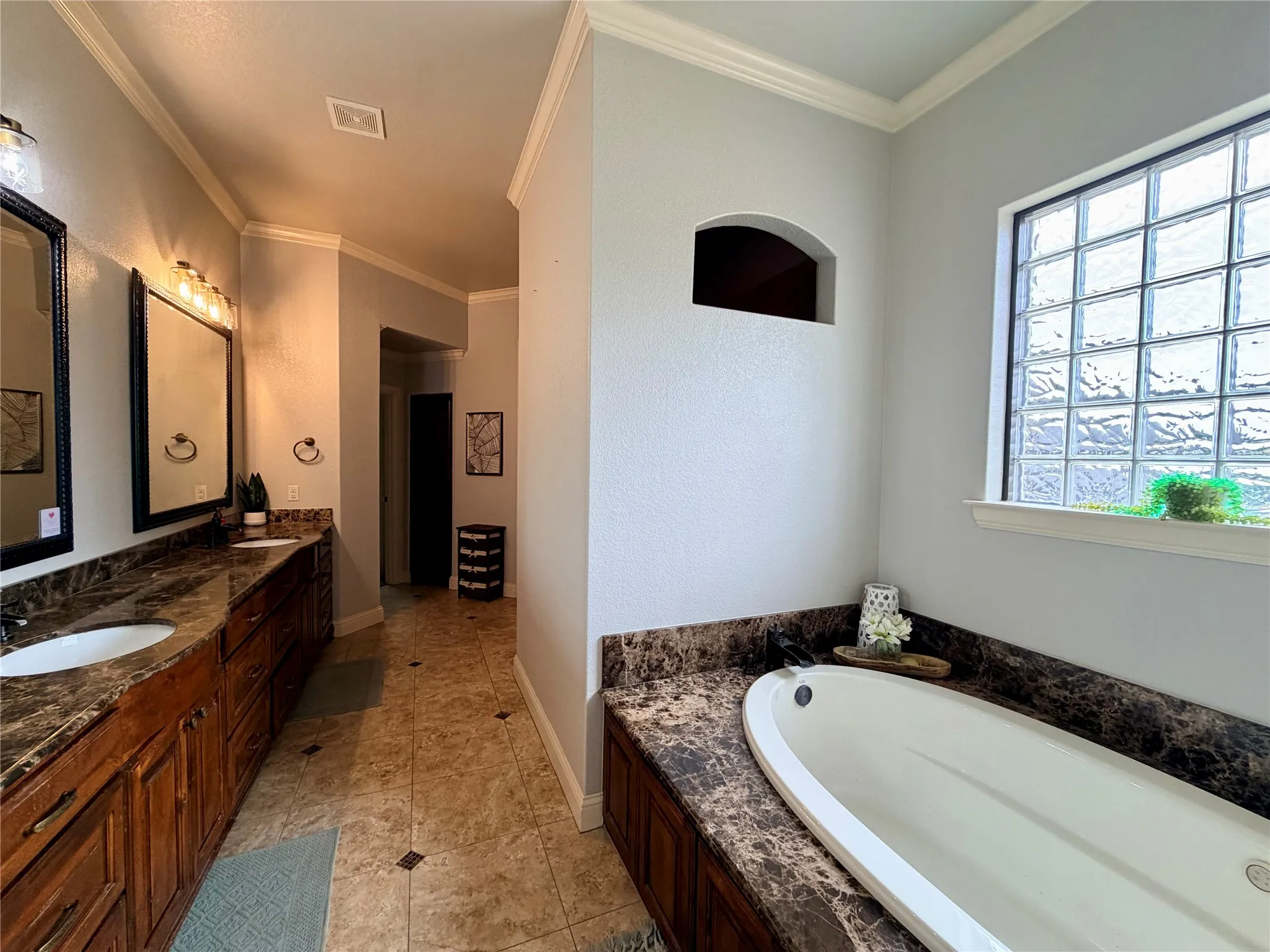 Dual vanity with undermount sinks, stone-finish countertops, and wood cabinetry