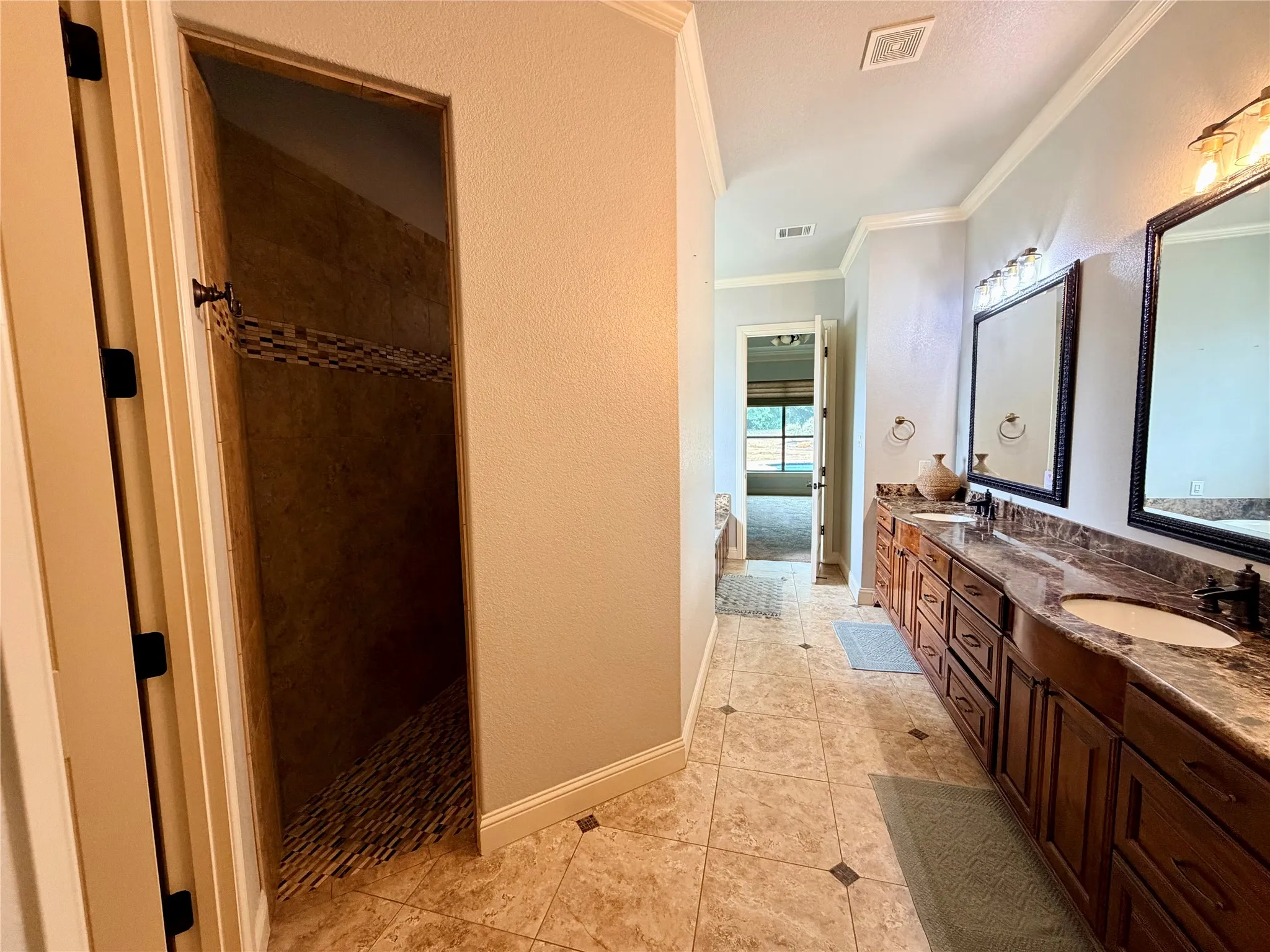 Dual vanity with dark wood cabinetry, integrated sinks, and stone countertops