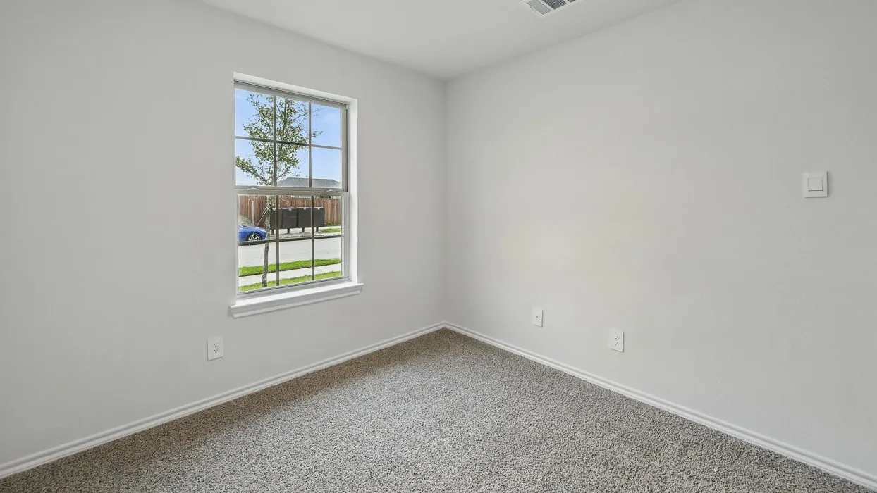 Neutral wall paint, window with grid panes, textured carpeting, and white trim