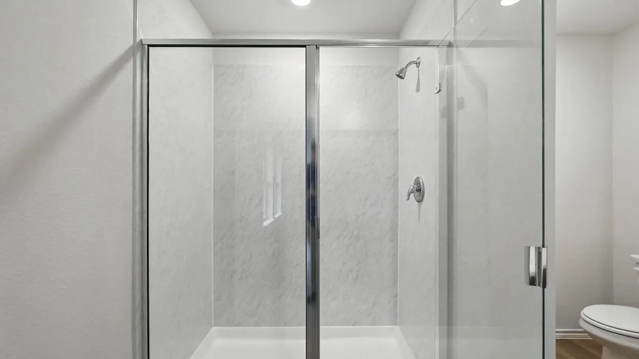 Glass-enclosed shower with a showerhead and separate control valve