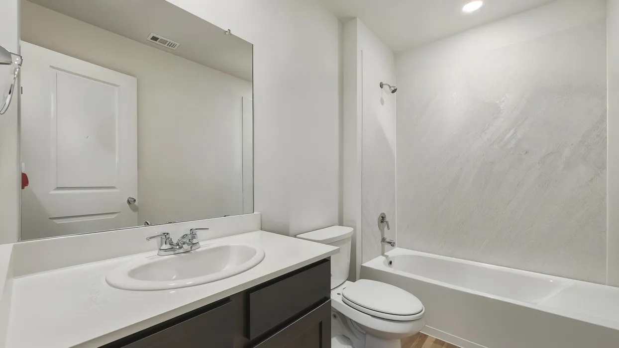 White rectangular vanity with undermount sink, dual-handle chrome faucet, and dark wood-finish cabinetry