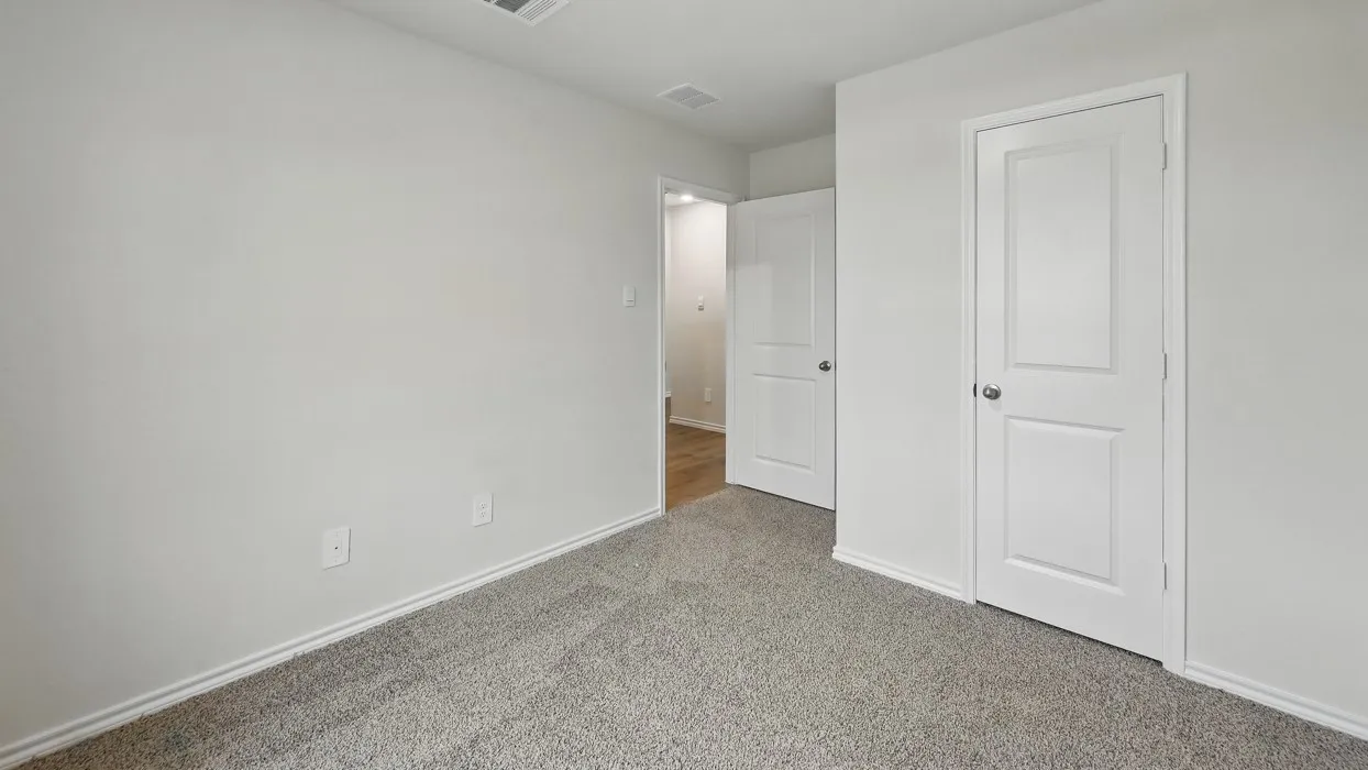 Neutral wall paint, light gray carpeting, and white trim