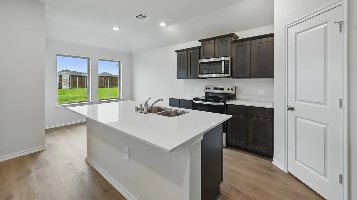 Kitchen featuring a center island with sink, dark wood-finish cabinetry, stainless steel appliances, wood-finish flooring, and recessed lighting