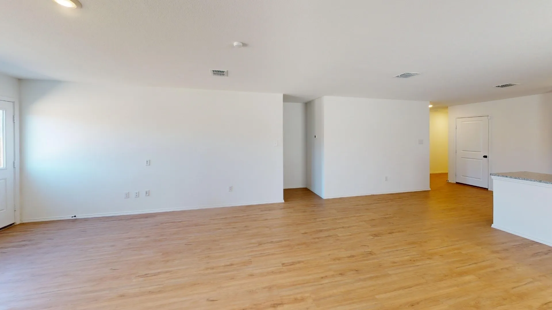 Wood-finish flooring, white walls, and recessed lighting