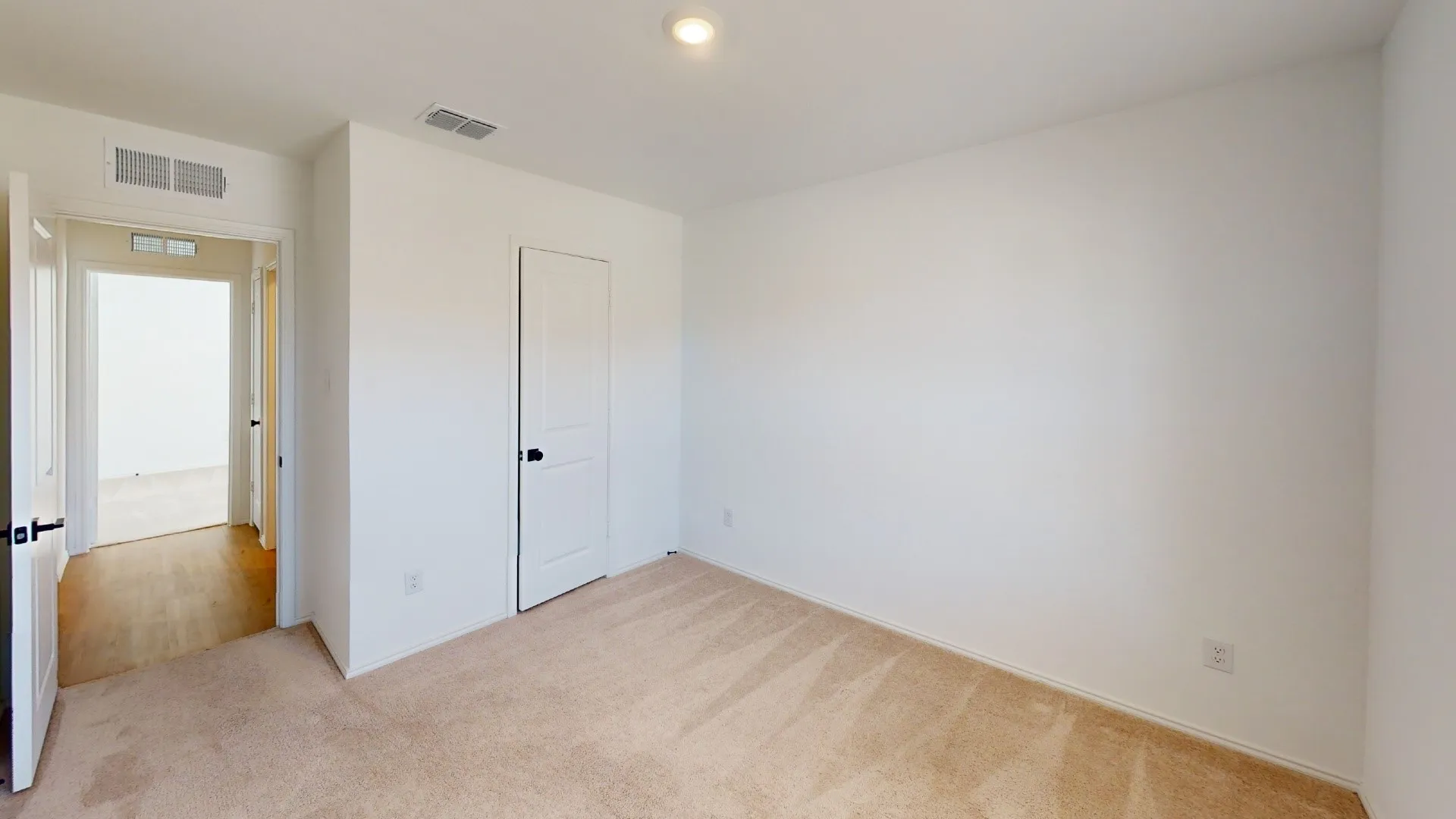 Neutral wall finishes, recessed ceiling light, and carpet flooring