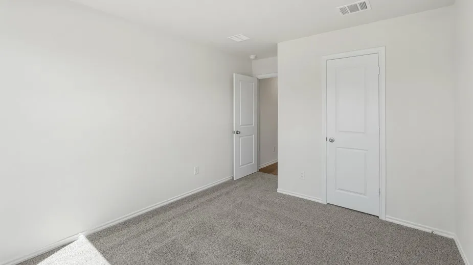 Recessed ceiling vent, neutral gray carpeting, white painted walls, and white paneled doors