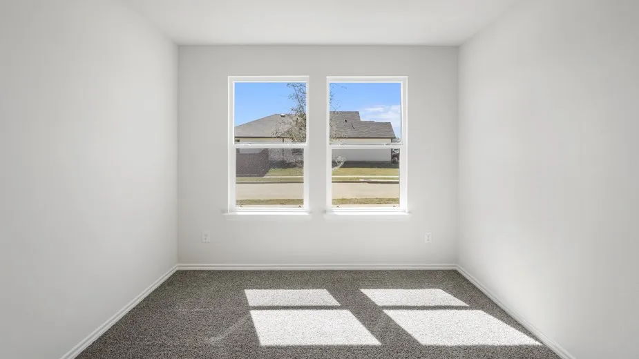 Neutral wall paint, plush carpet flooring, and two windows with white trim