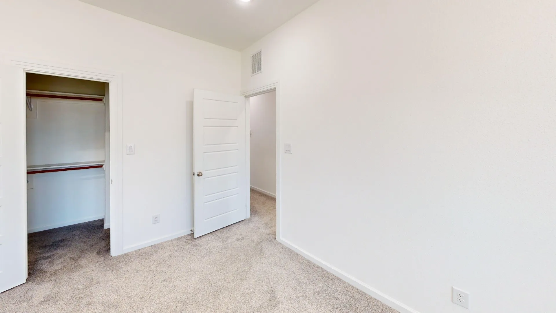 Neutral color palette throughout, featuring light-toned carpeting and white walls