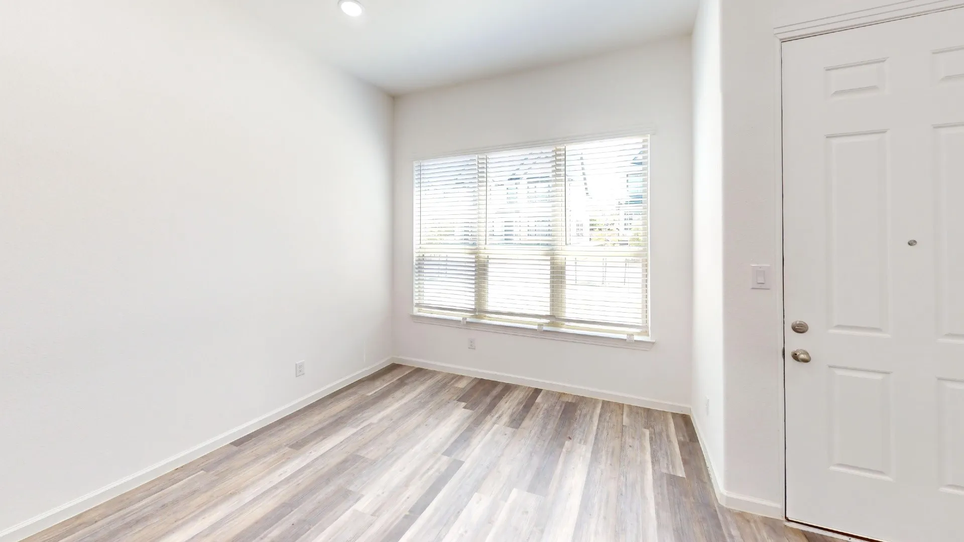 Wood-finish flooring, recessed lighting, and a paneled entry door