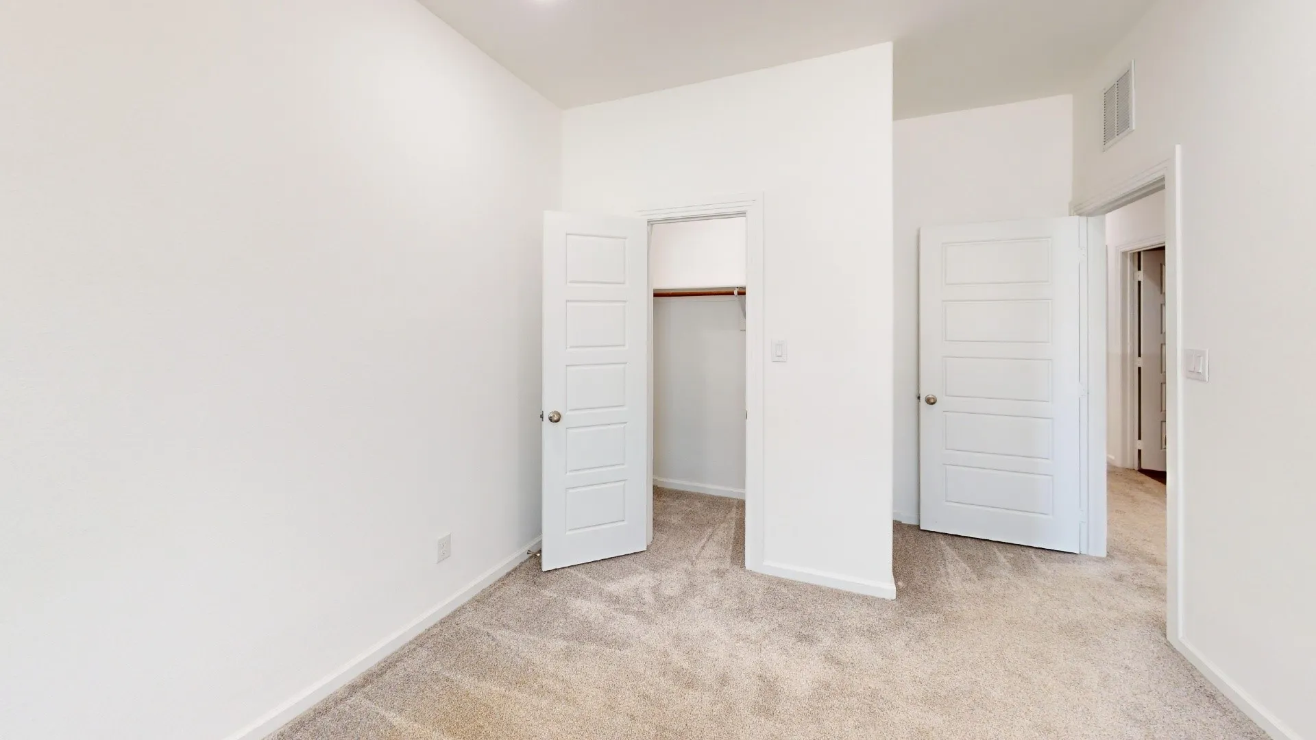Neutral-toned carpeting, white walls, and a recessed ceiling light
