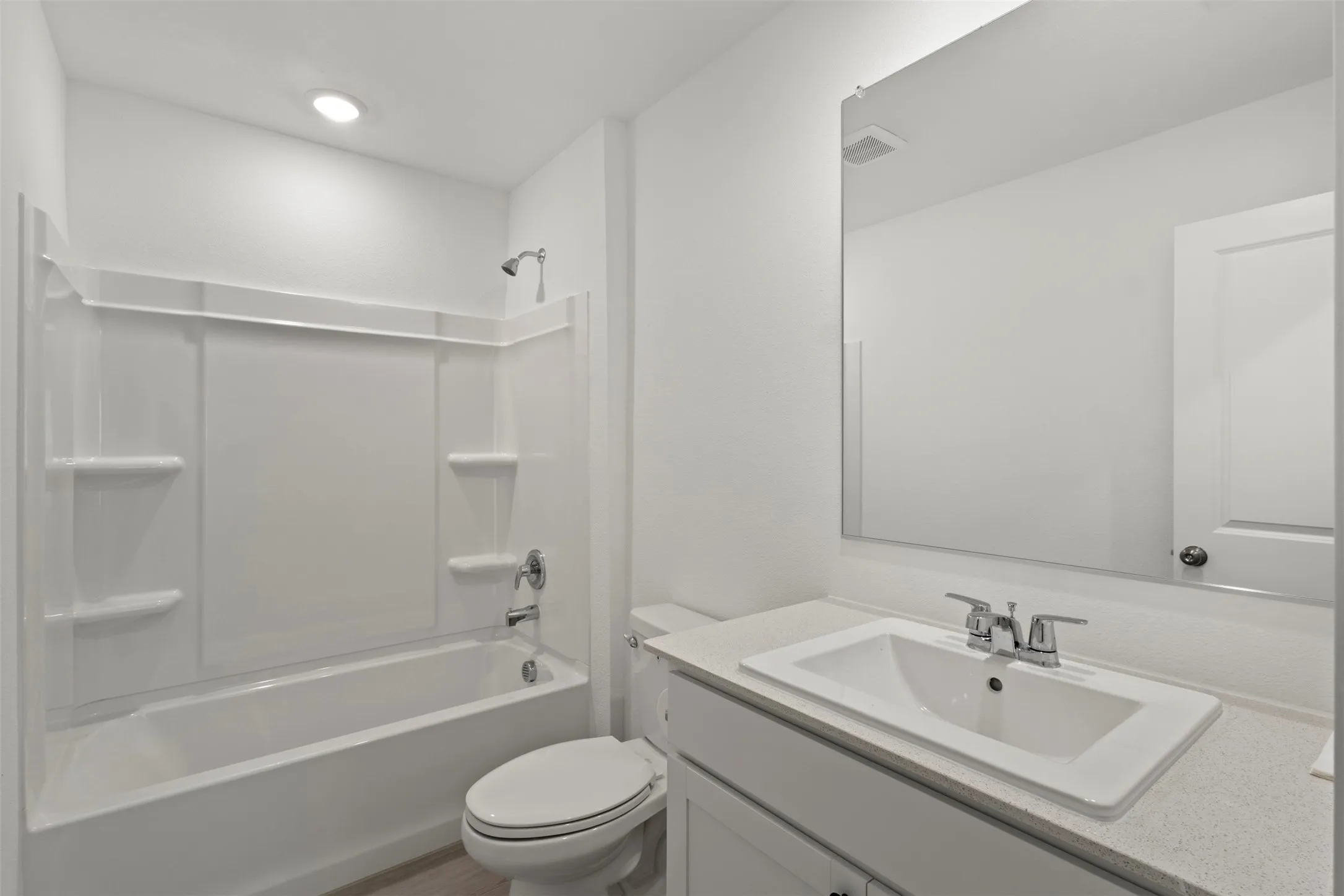White vanity with a rectangular undermount sink, chrome faucet, and light-colored countertop