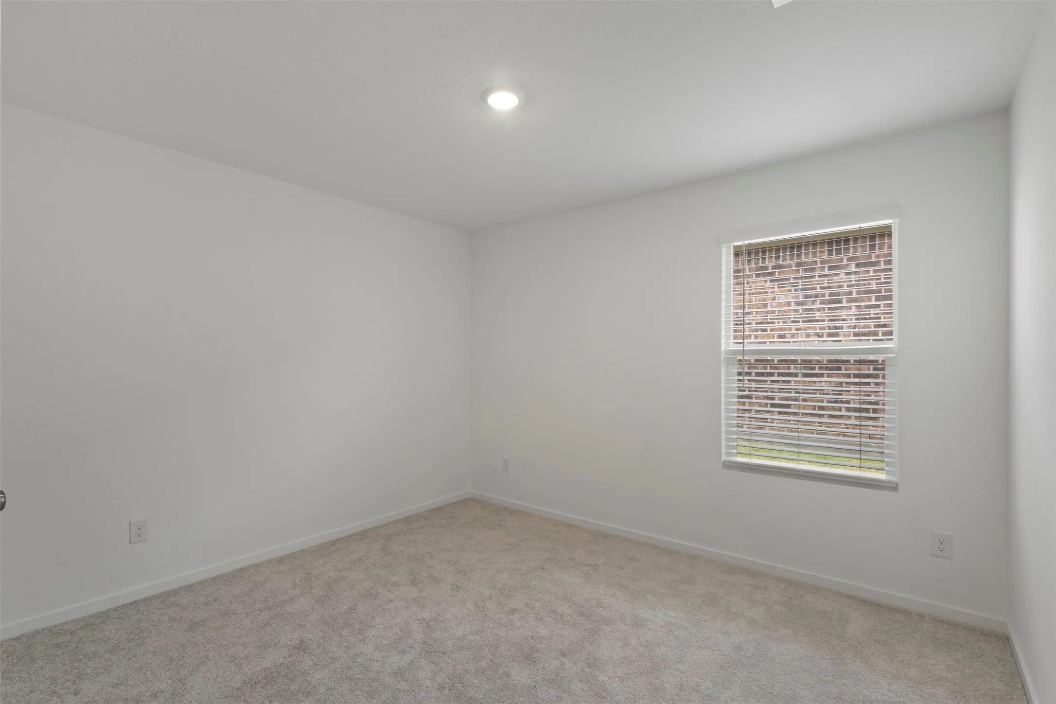 Recessed ceiling lighting, neutral carpeting, window with blinds, and light-toned walls