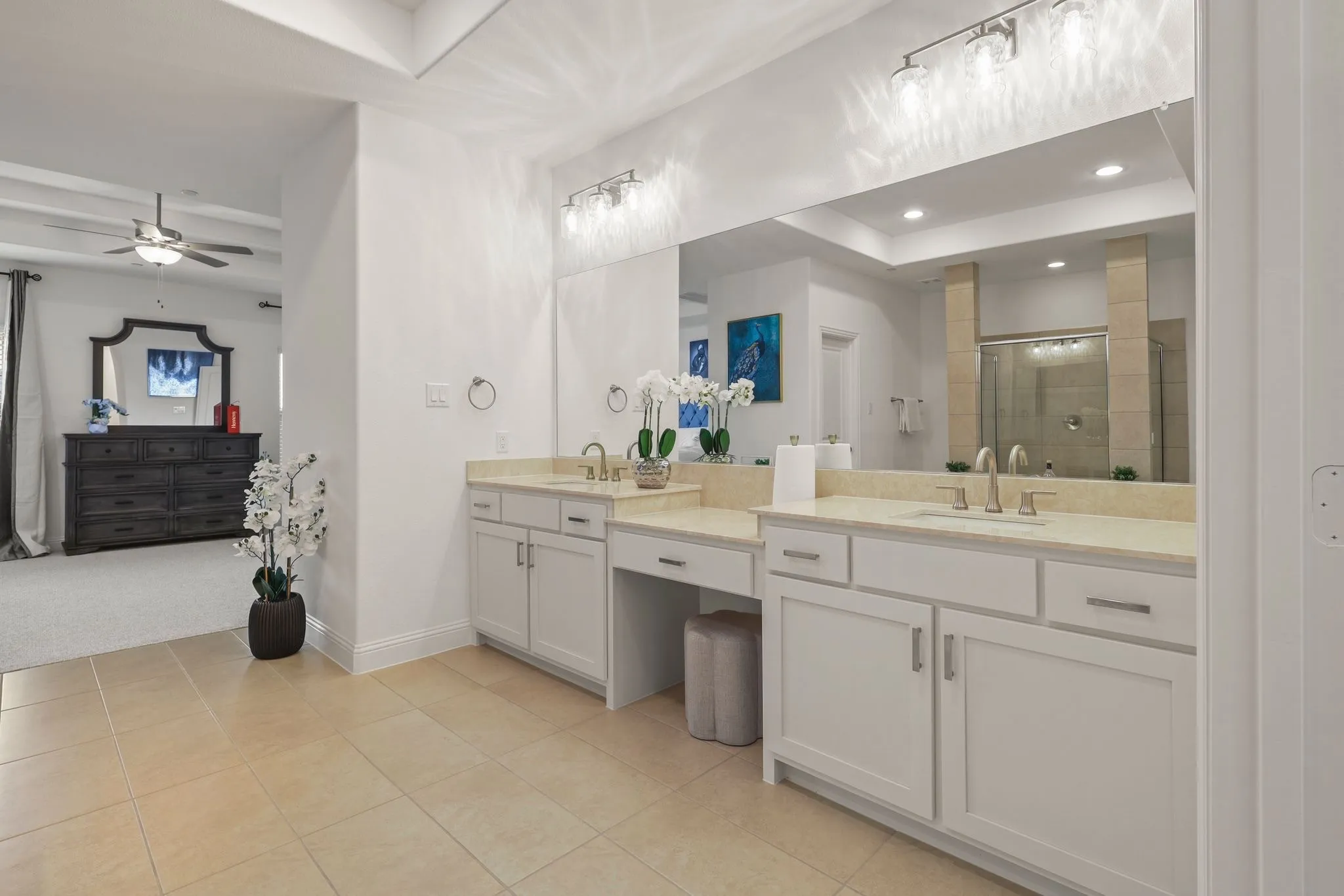 Bathroom with ceiling fan, tile patterned floors, a shower with door, and vanity