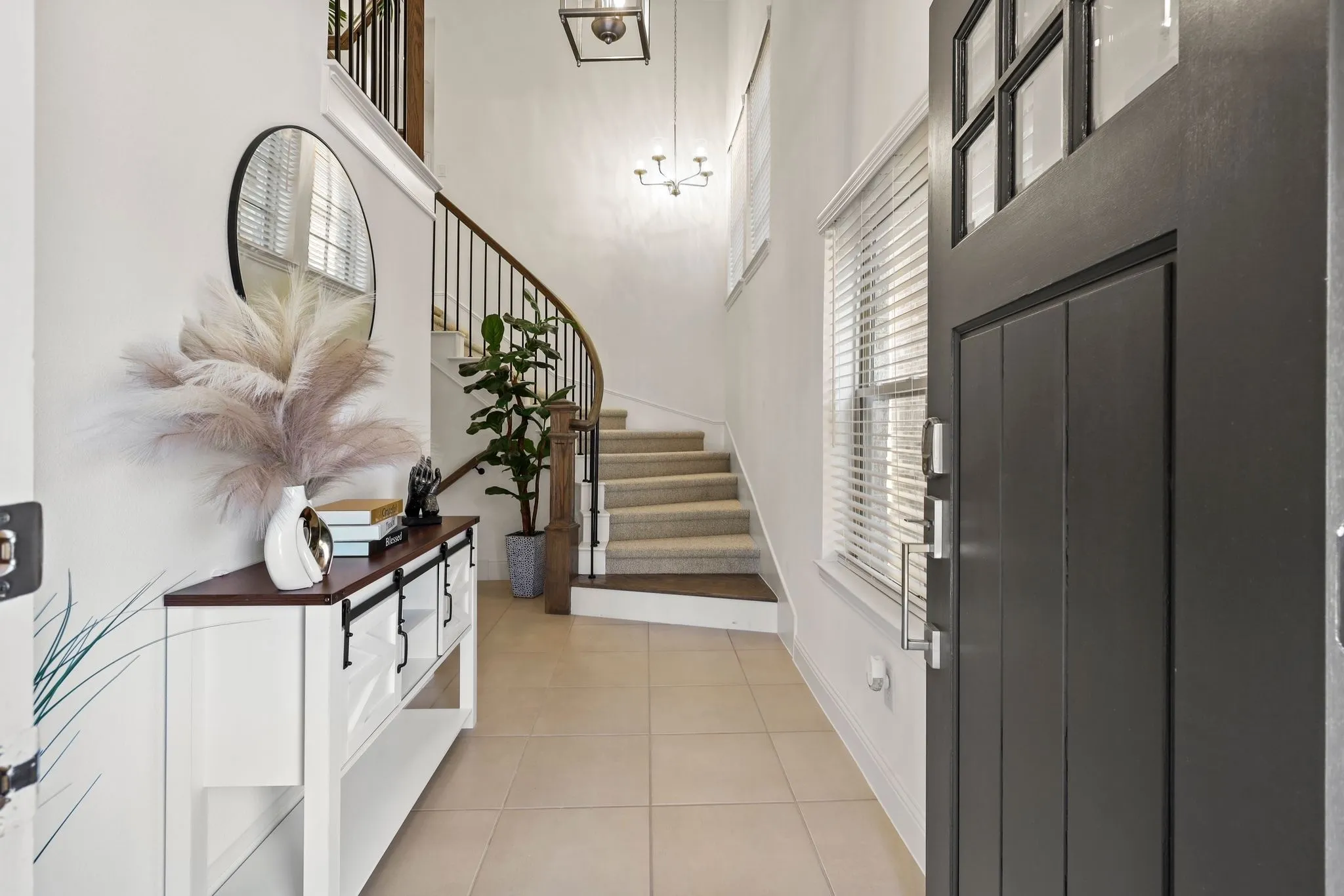 Foyer with light tile patterned floors and a high ceiling
