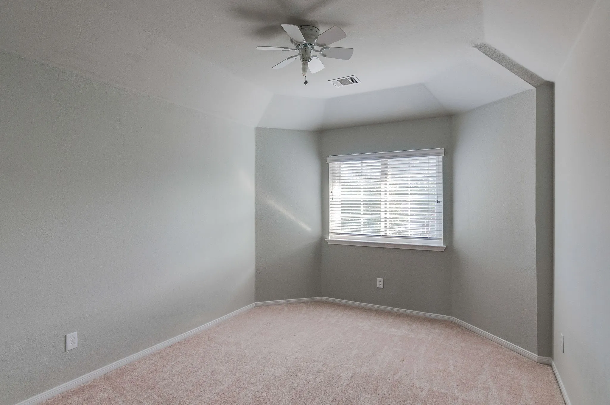 Recessed window with white blinds, neutral wall paint, and beige carpet flooring