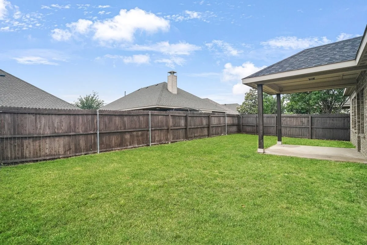 Expansive green lawn with a wood privacy fence