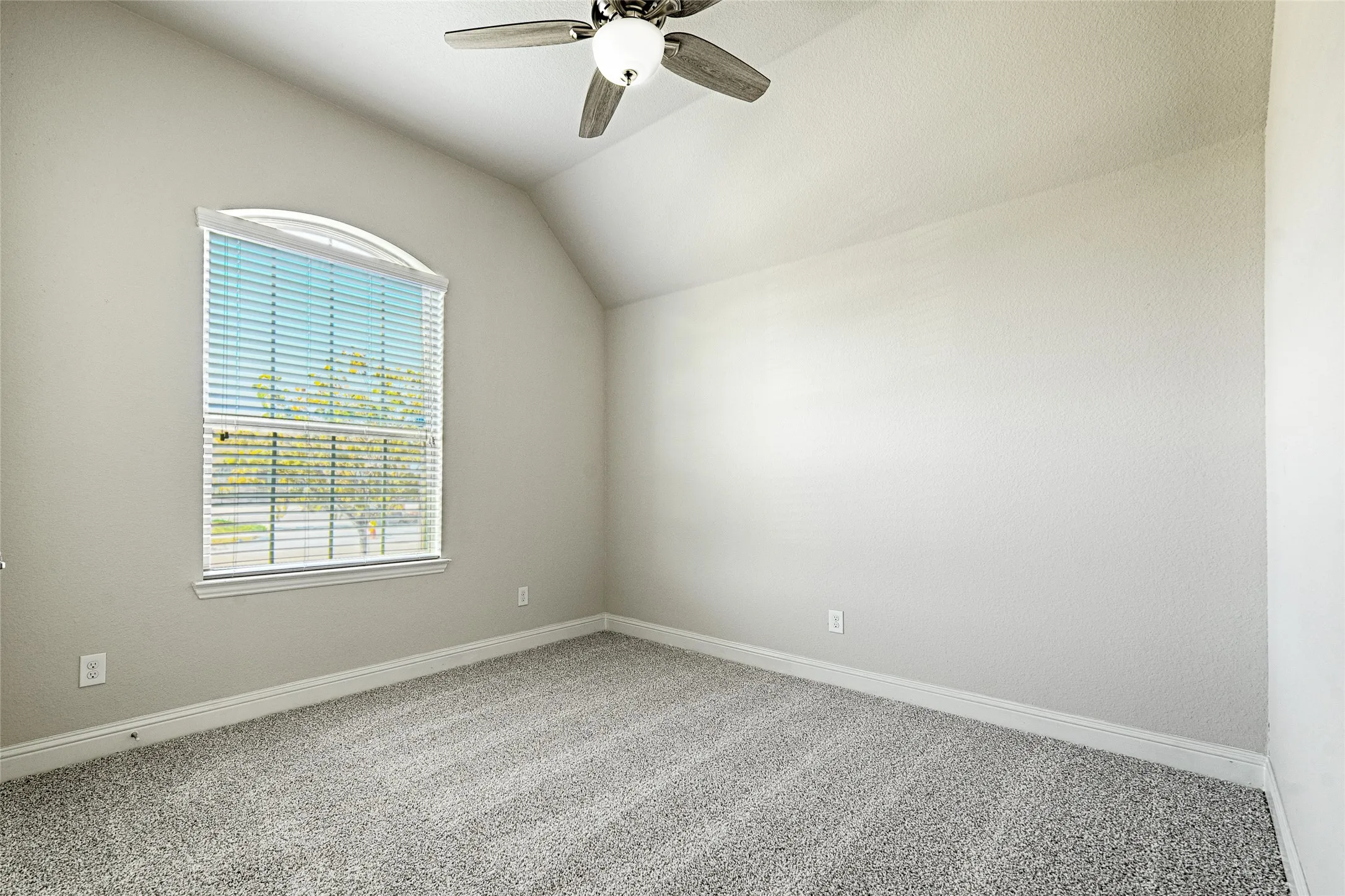 Secondary bedroom with blinds, ceiling fan, and light gray textured carpeting