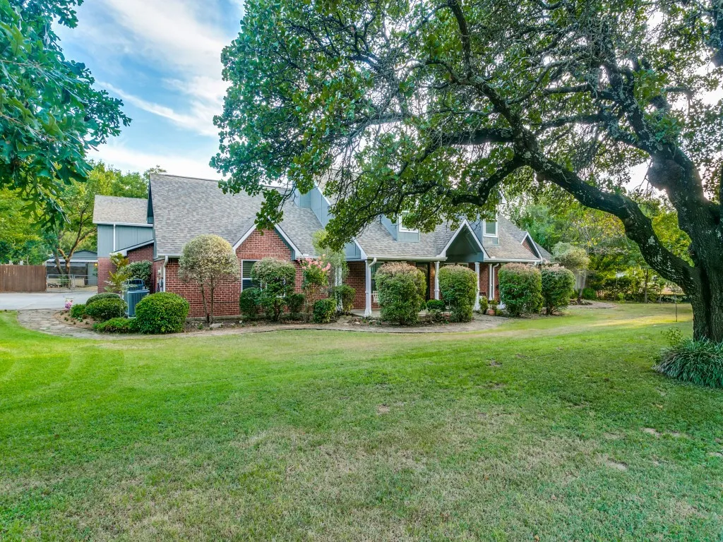 Expansive front lawn with mature trees and established landscaping