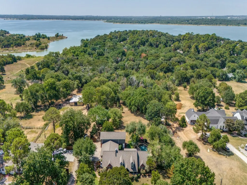 Aerial property perspective featuring a body of water and expansive tree coverage
