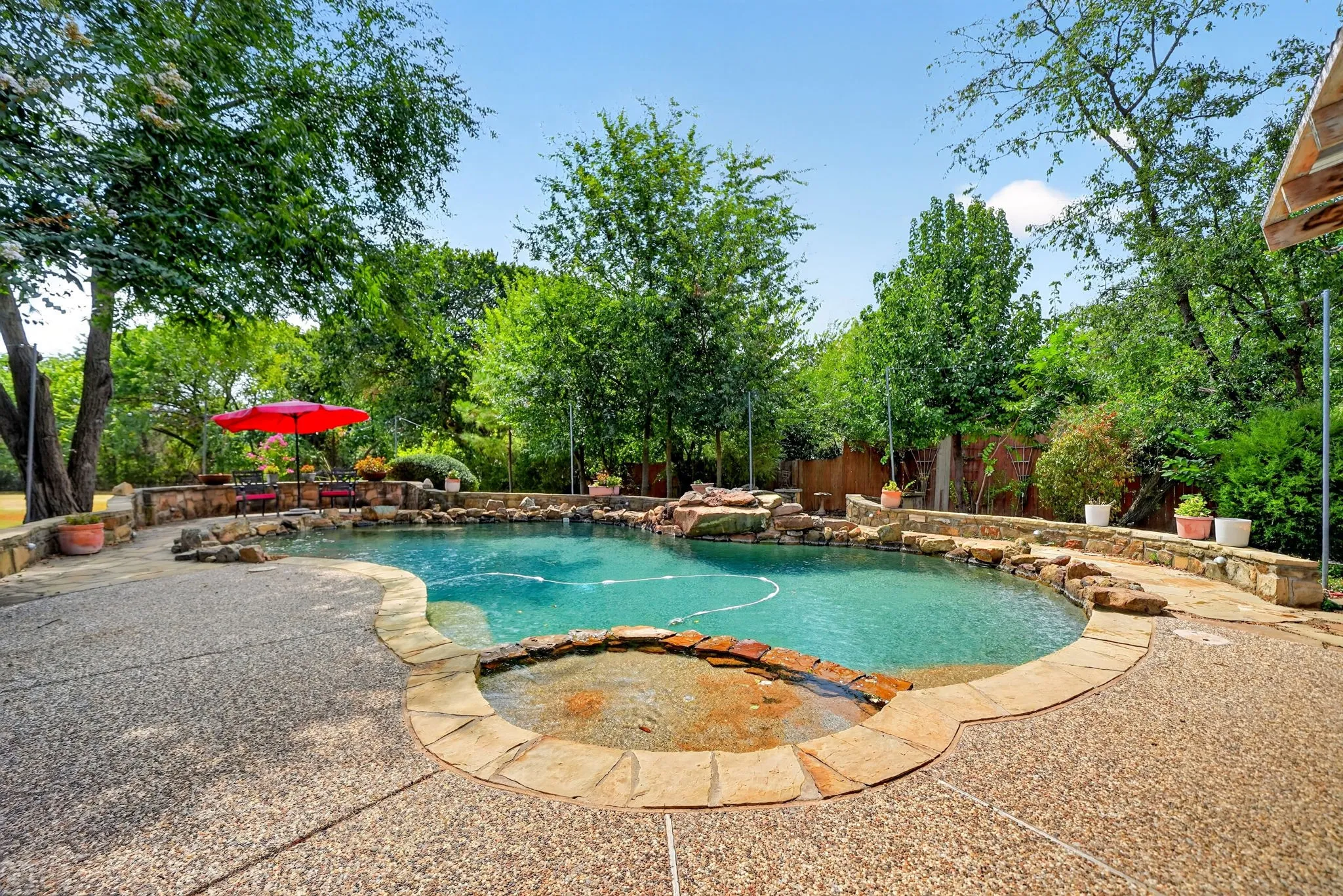 Lagoon-style pool with integrated spa and rock-faced retaining walls