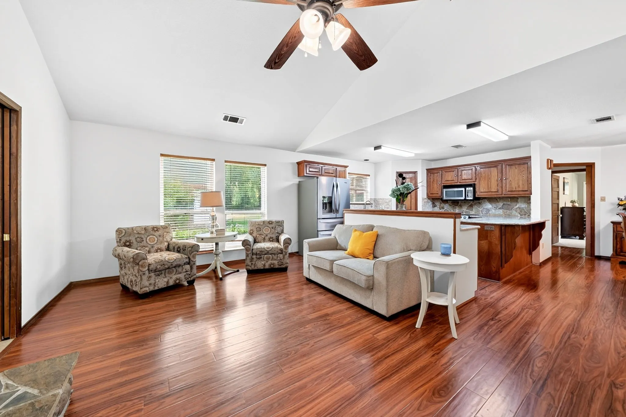 Vaulted ceilings, wood-finish flooring, ample natural light, built-in cabinetry, and stainless steel appliances