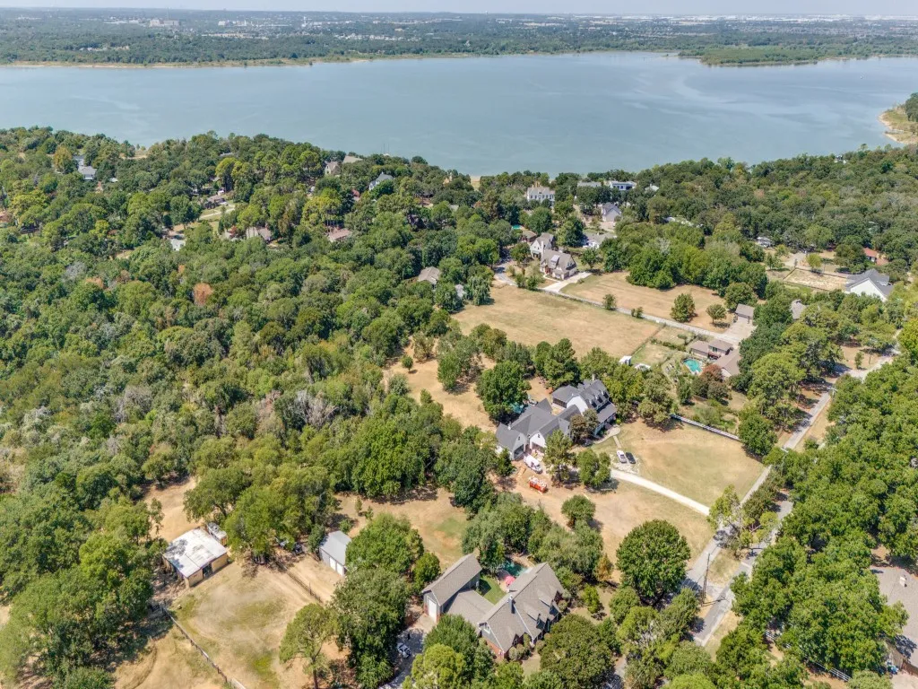 Expansive property featuring a large body of water, mature tree coverage, multiple residences, and open land areas