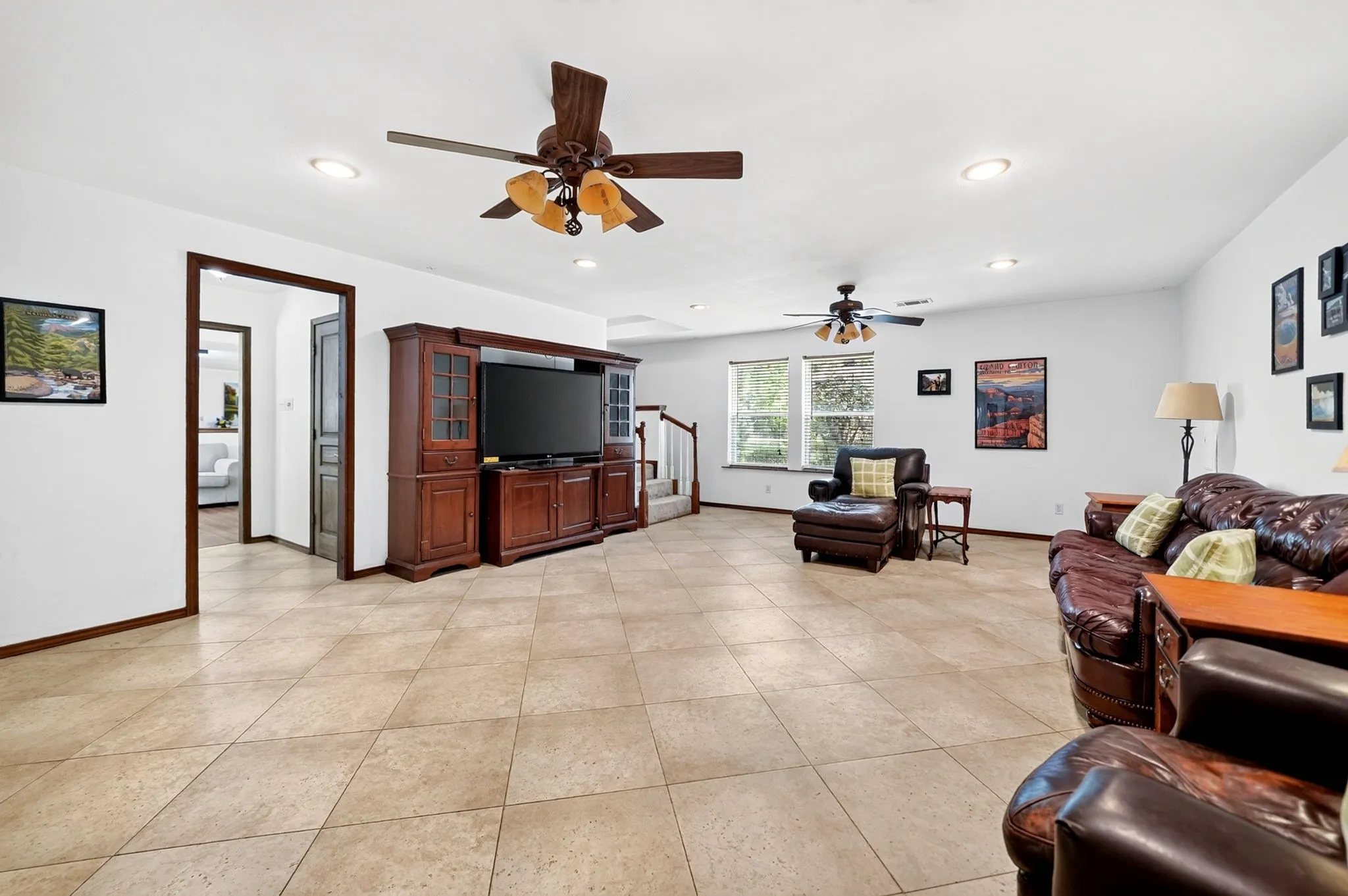 Spacious main living area featuring tile flooring, recessed lighting, and multiple ceiling fans