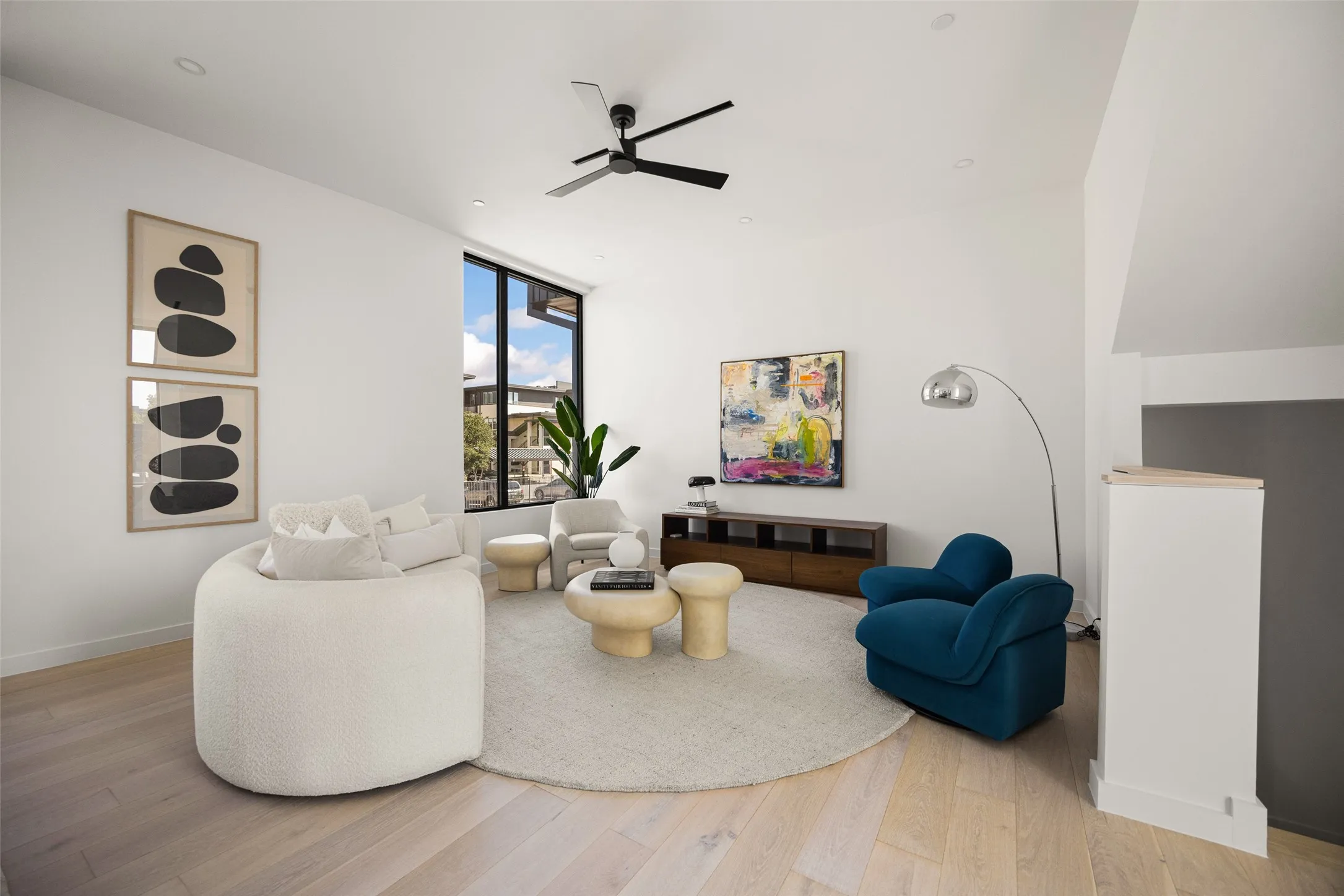 Hardwood flooring, recessed lighting, modern ceiling fan, large window, and built-in media console