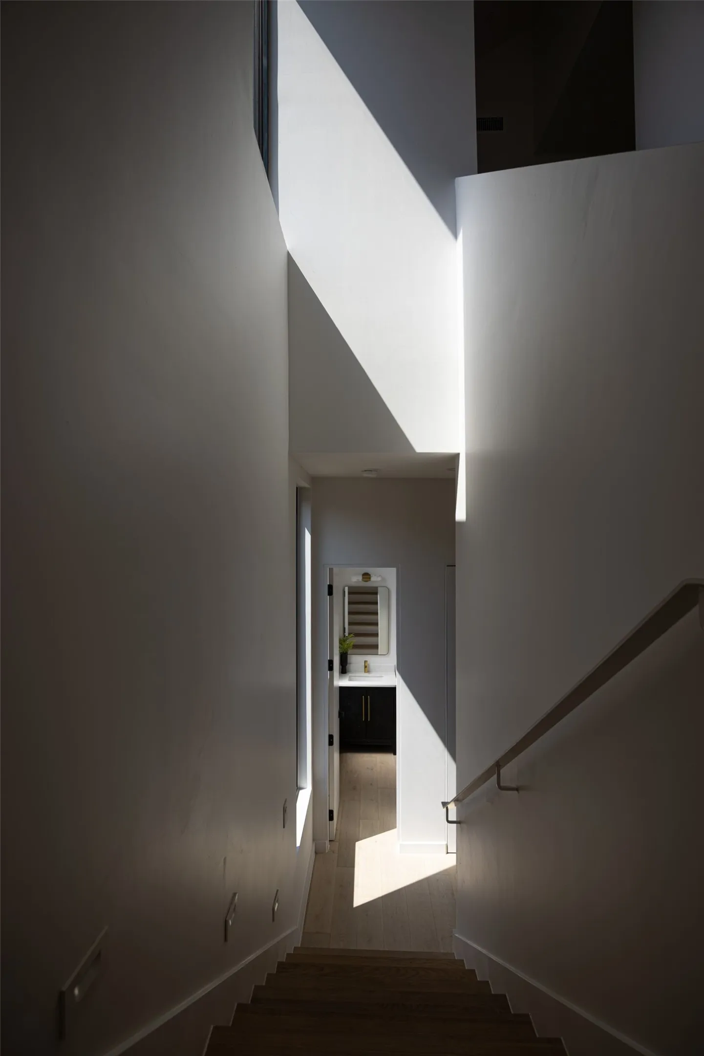 Wood-finish stair treads with a wall-mounted handrail