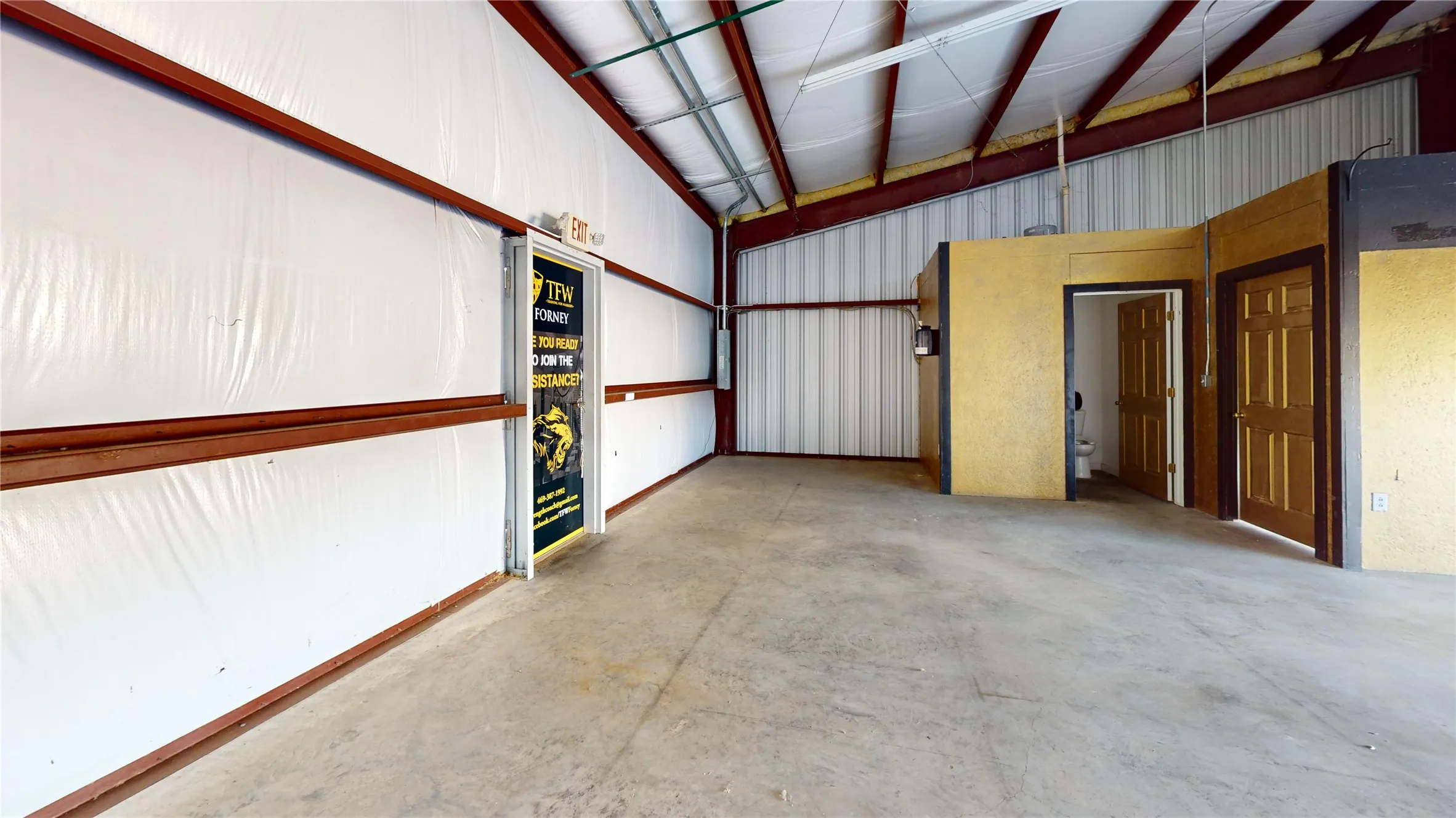 High ceilings with exposed metal beams, concrete flooring, interior partitioned office spaces, and a built-in bathroom
