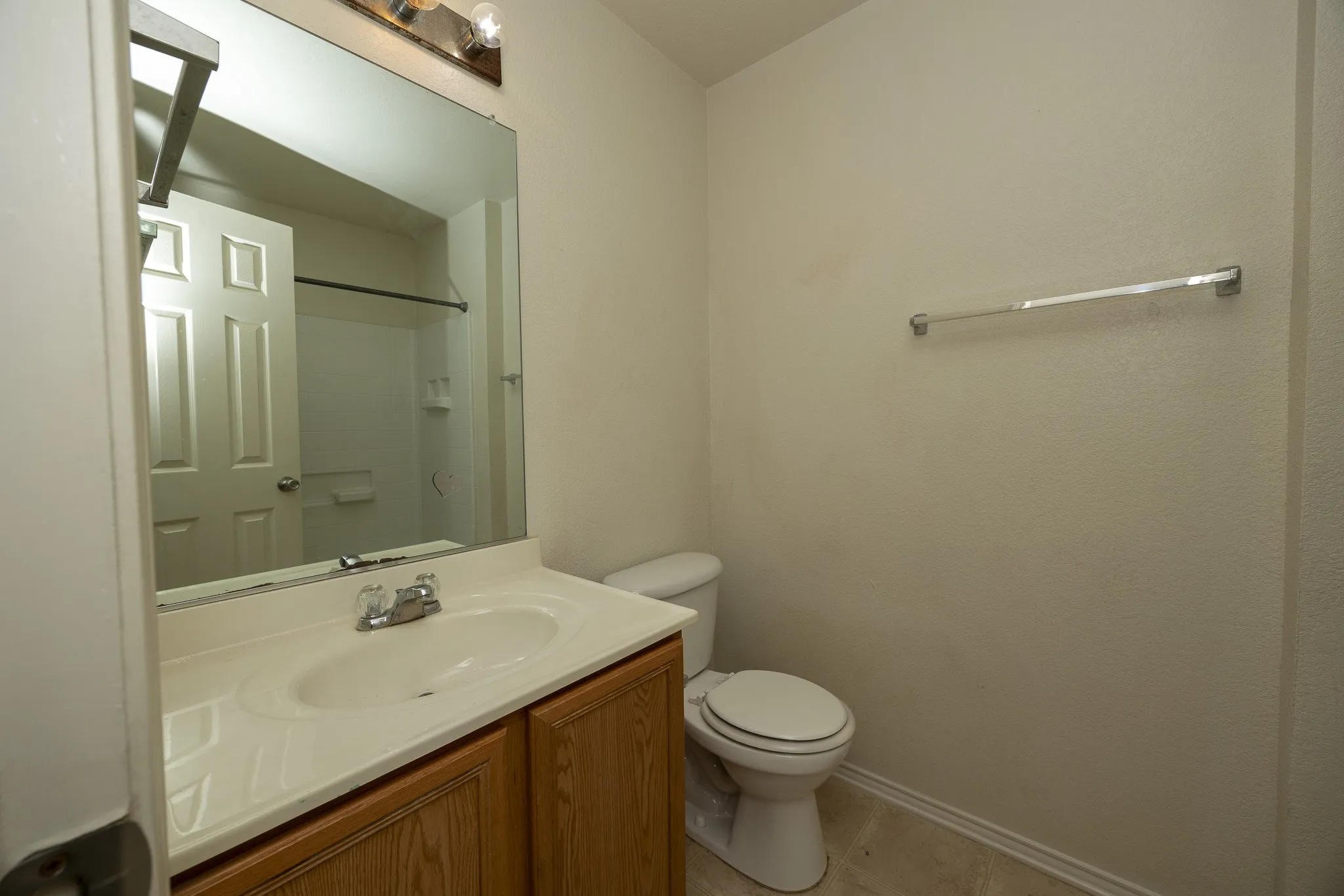 Bathroom featuring a wood-finish vanity, integrated sink, and chrome fixtures