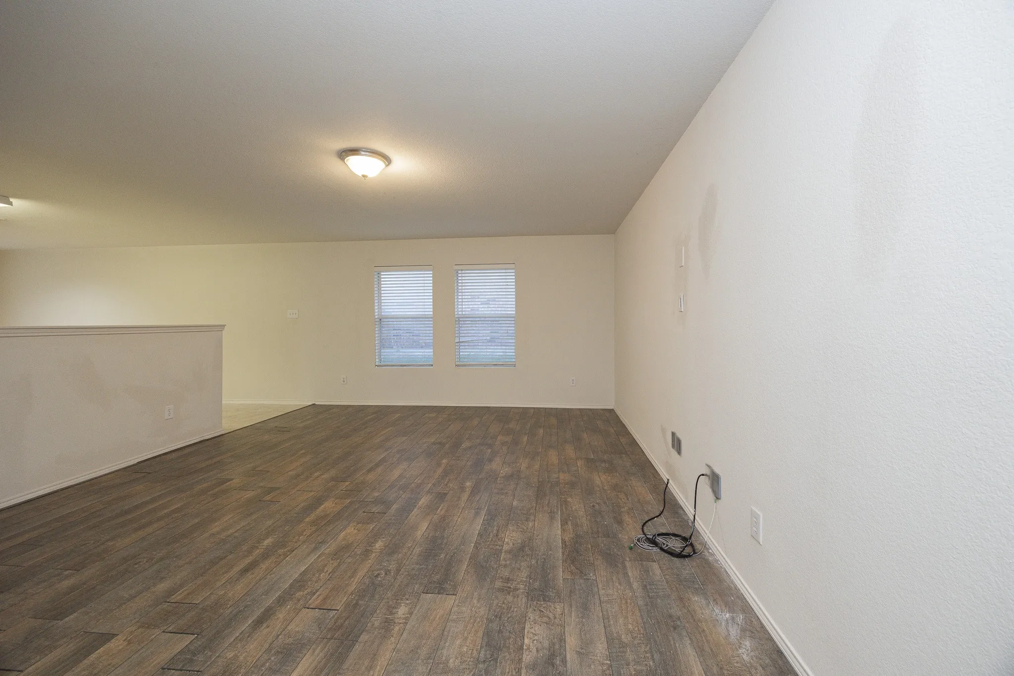 Wood-finish flooring with white walls and a white half-wall partition