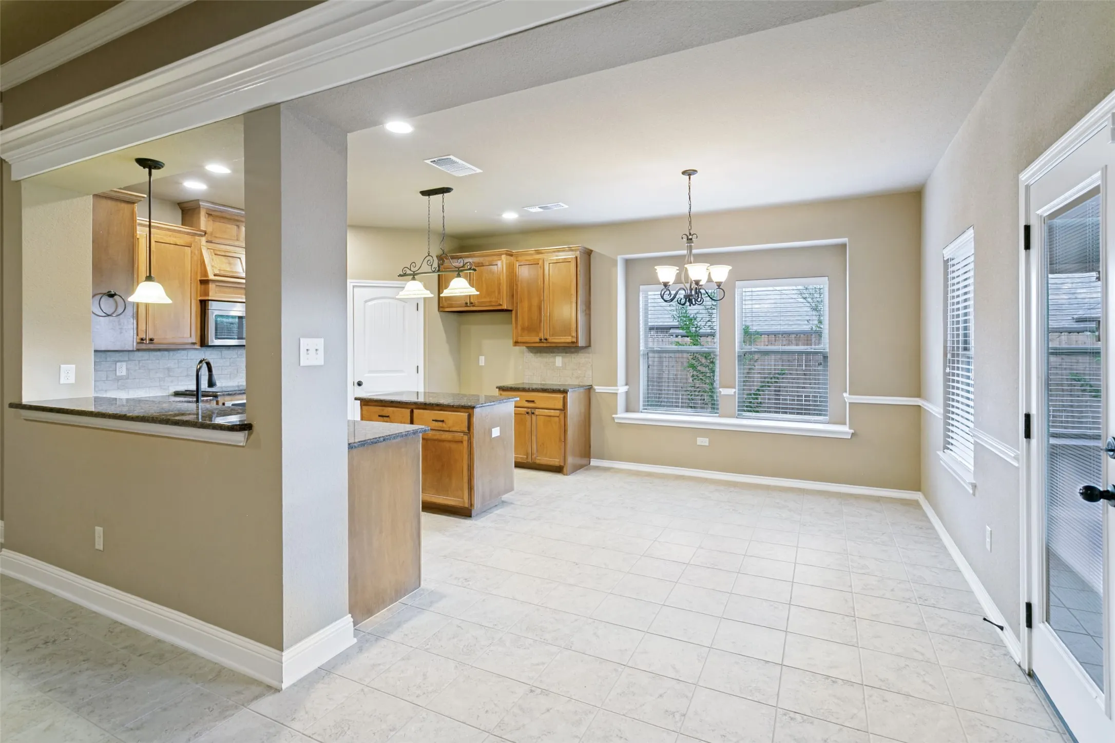 View of the kitchen and dining room from the living room. Back door leads to covered patio.