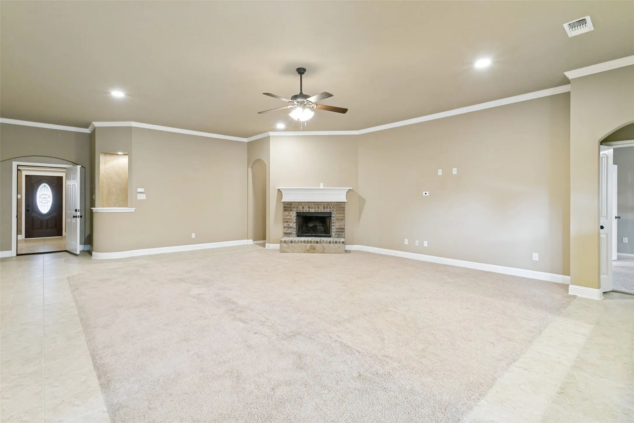 View of the living room from the kitchen. Large room with fireplace.