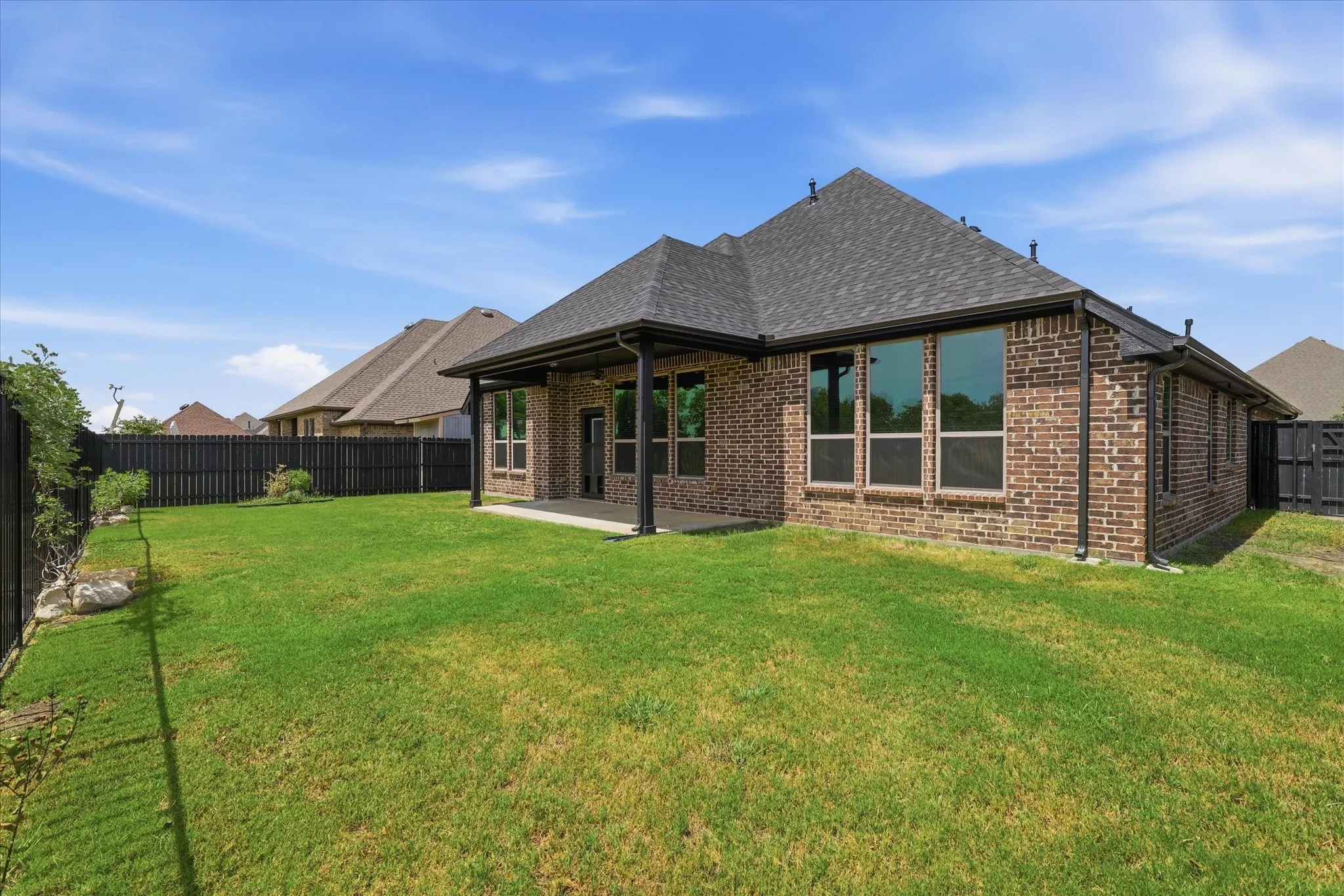 Fully fenced backyard with a broad lawn and room for additional landscaping, play space, pets or a future outdoor feature.