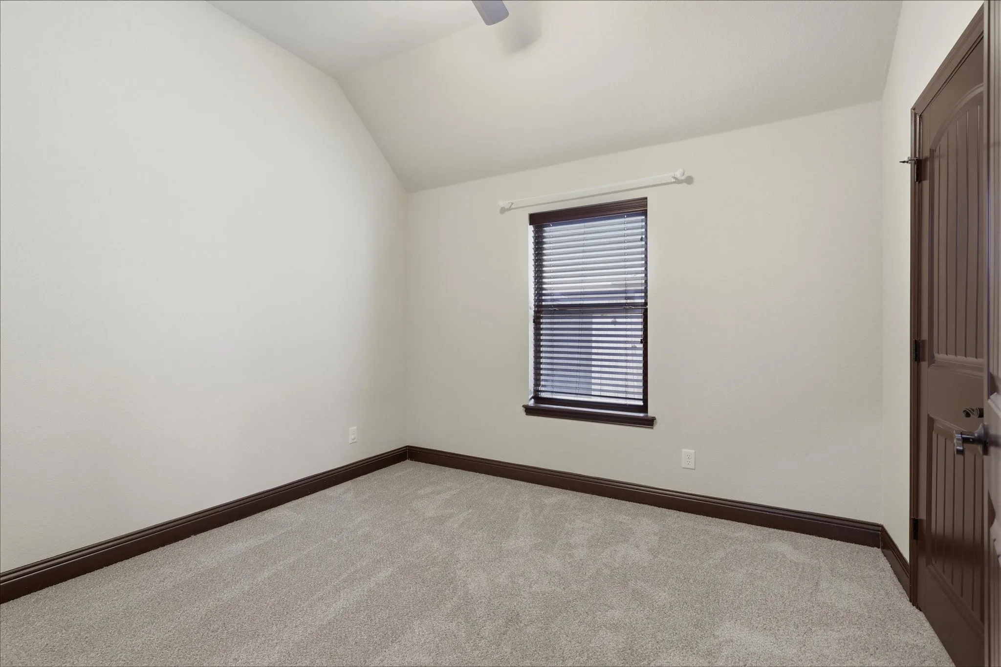 Spacious secondary bedroom features new carpet, window covering and ceiling fan.
