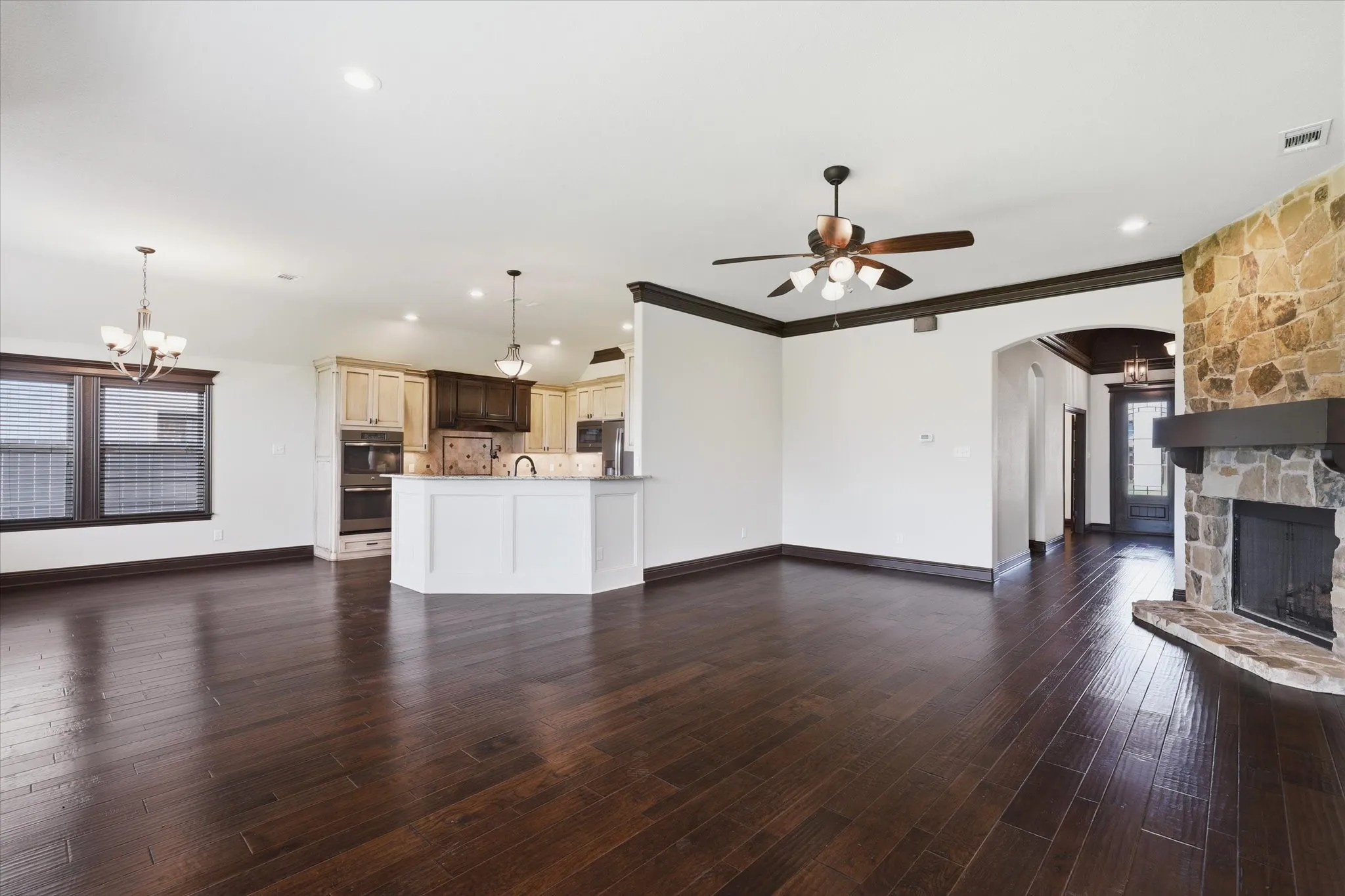 Deep crown molding, oversized baseboards, recessed lighting and the open connection to the kitchen add to the room's architectural character.