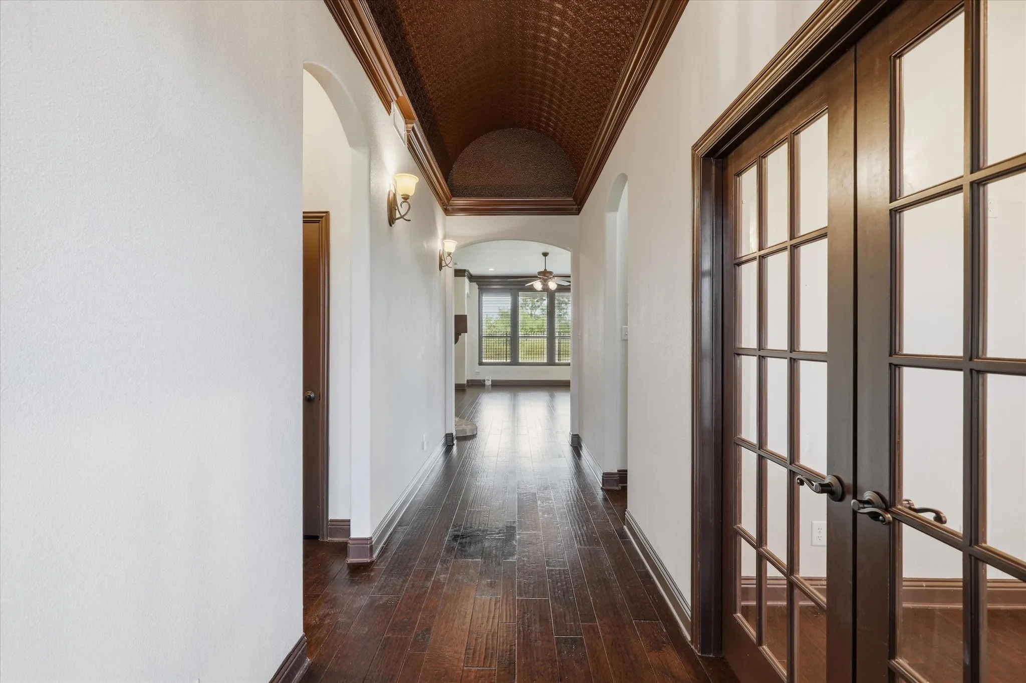 Dramatic entry with standout  feature of the custom barrel-vaulted ceiling with a decorative textured finish, framed by deep crown molding and accented with wall sconces.