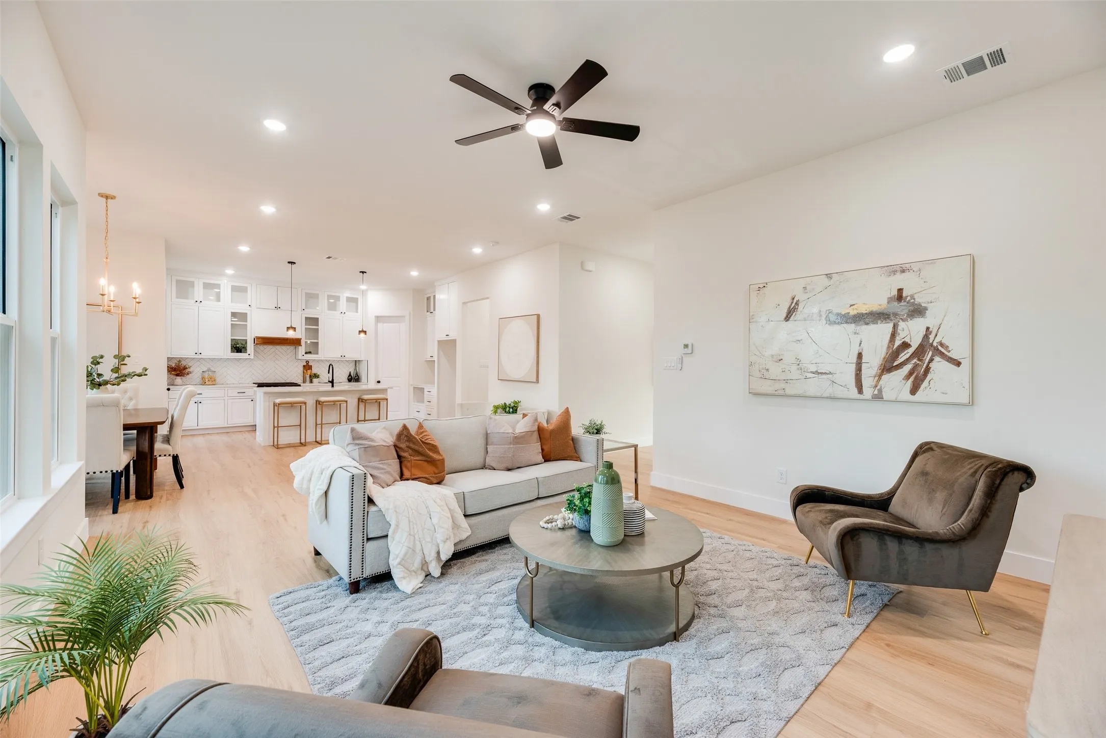 Open-concept living space featuring wood-finish flooring, recessed lighting, and a ceiling fan