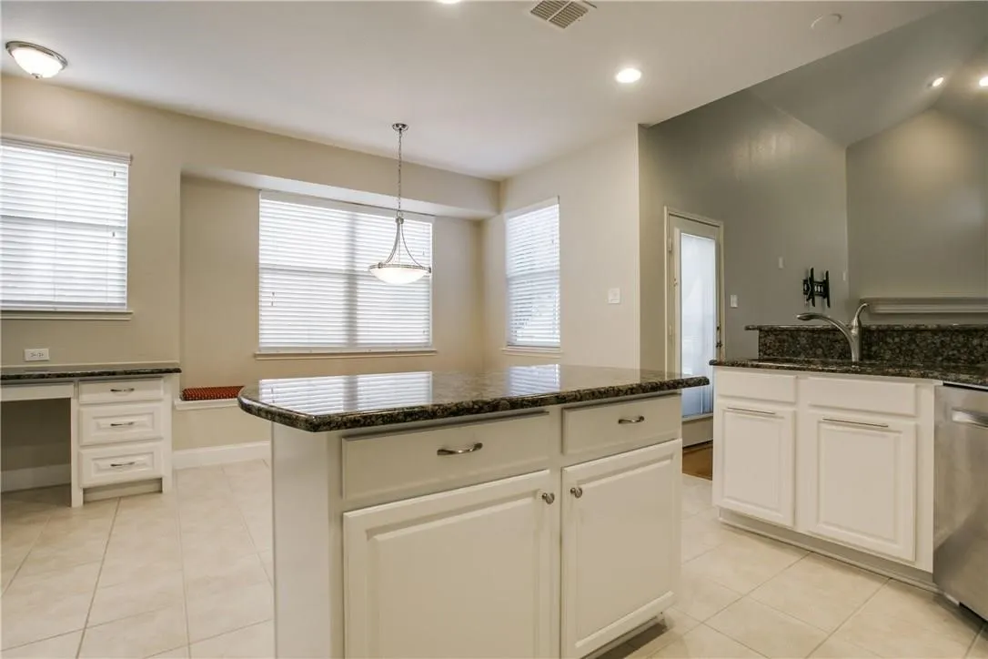 Kitchen featuring white cabinetry, a center island, and light tile patterned floors