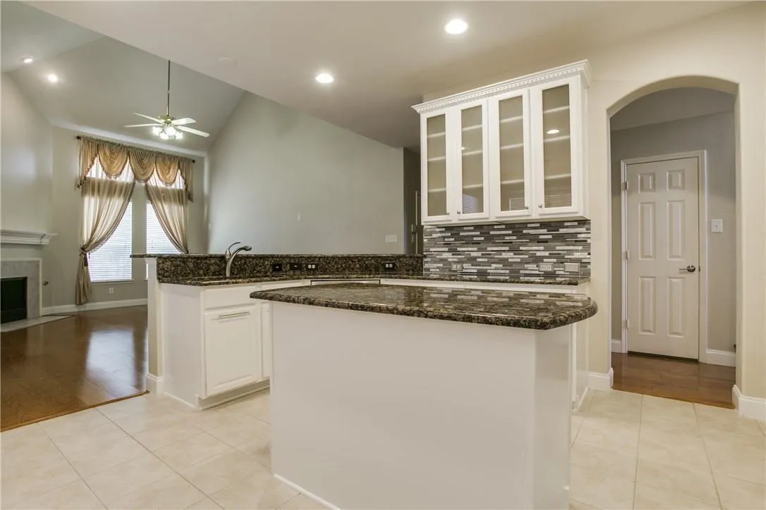 Kitchen featuring white cabinets, lofted ceiling, and light tile patterned floors